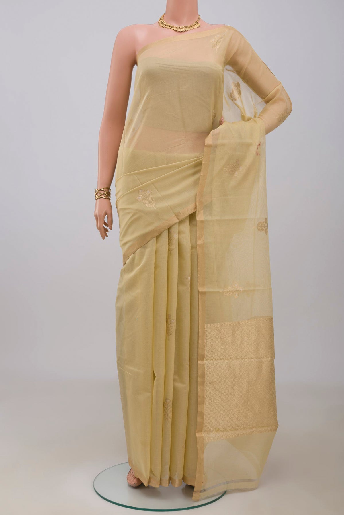 Cream Banarasi Kora Cotton Saree with Zari Butta on the body and Zari Border.  displayed on a mannequin