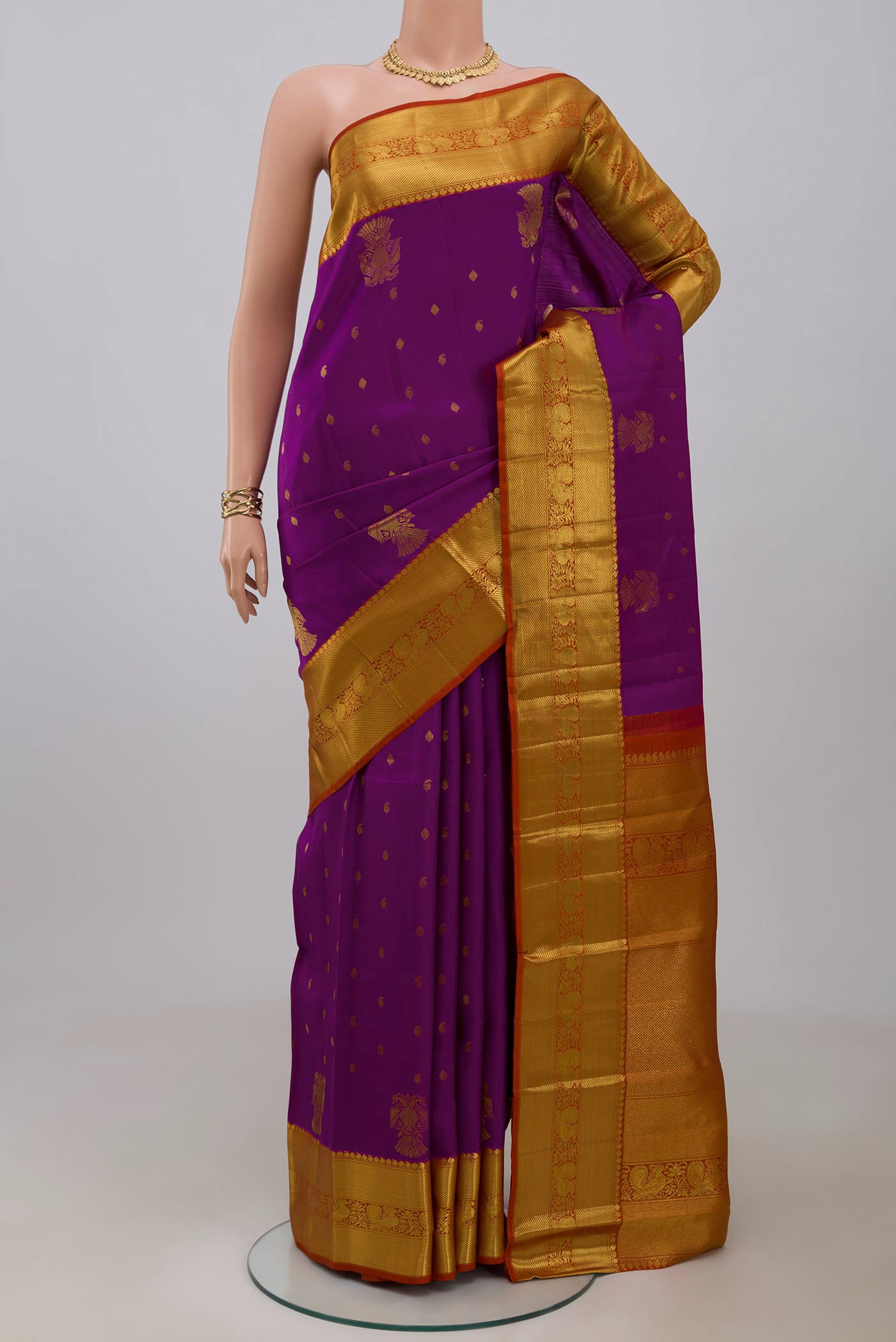 Magenta Kanjivaram Saree with Zari Butta on the body and Zari Border.  displayed on a mannequin