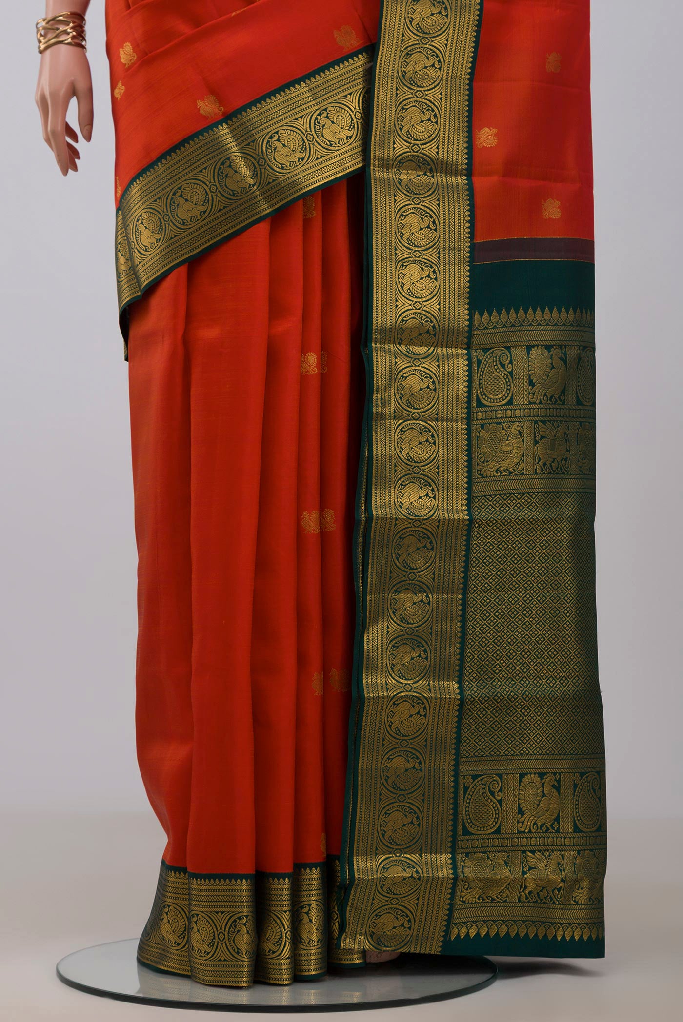 Pleats and pallu of Orange Kanjivaram Silk Saree with Zari Butta on the body and Zari Border. 