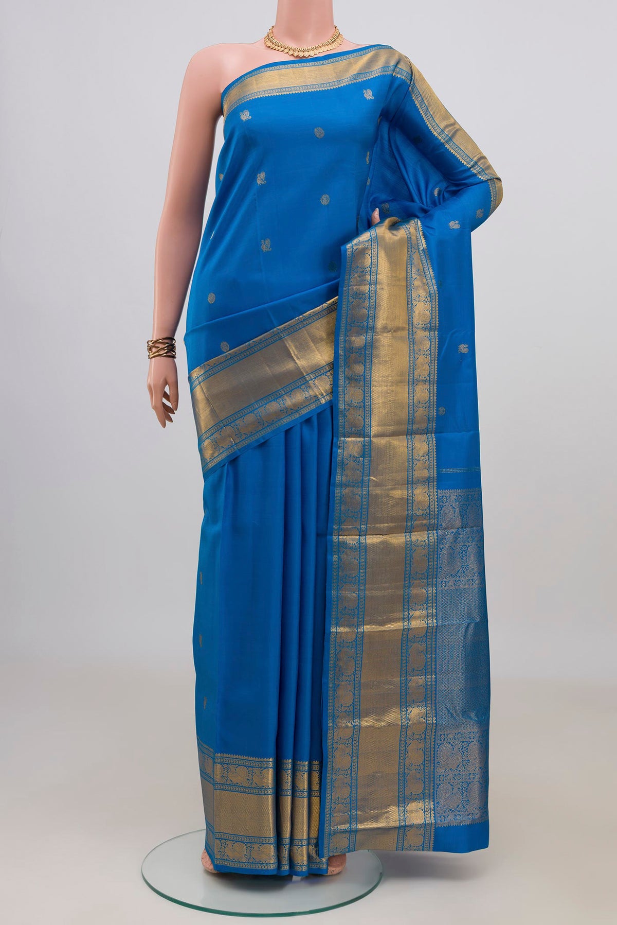 Pure Silk Blue Kanjivaram Saree with Zari Butta on the body and Zari Border.  displayed on a mannequin