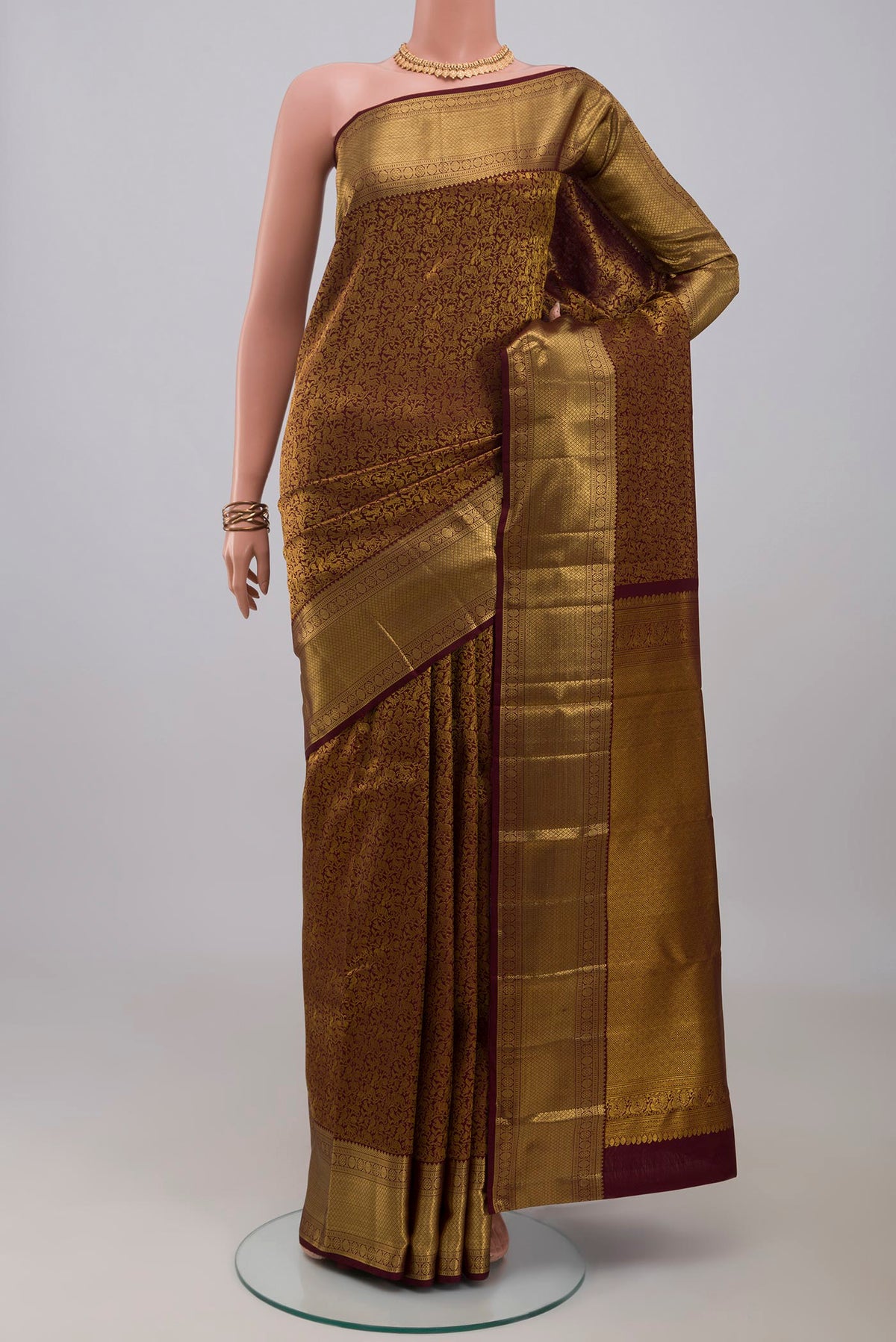 Brown Kanchipuram Silk Saree with Zari Brocade on the body and Zari Border.  displayed on a mannequin