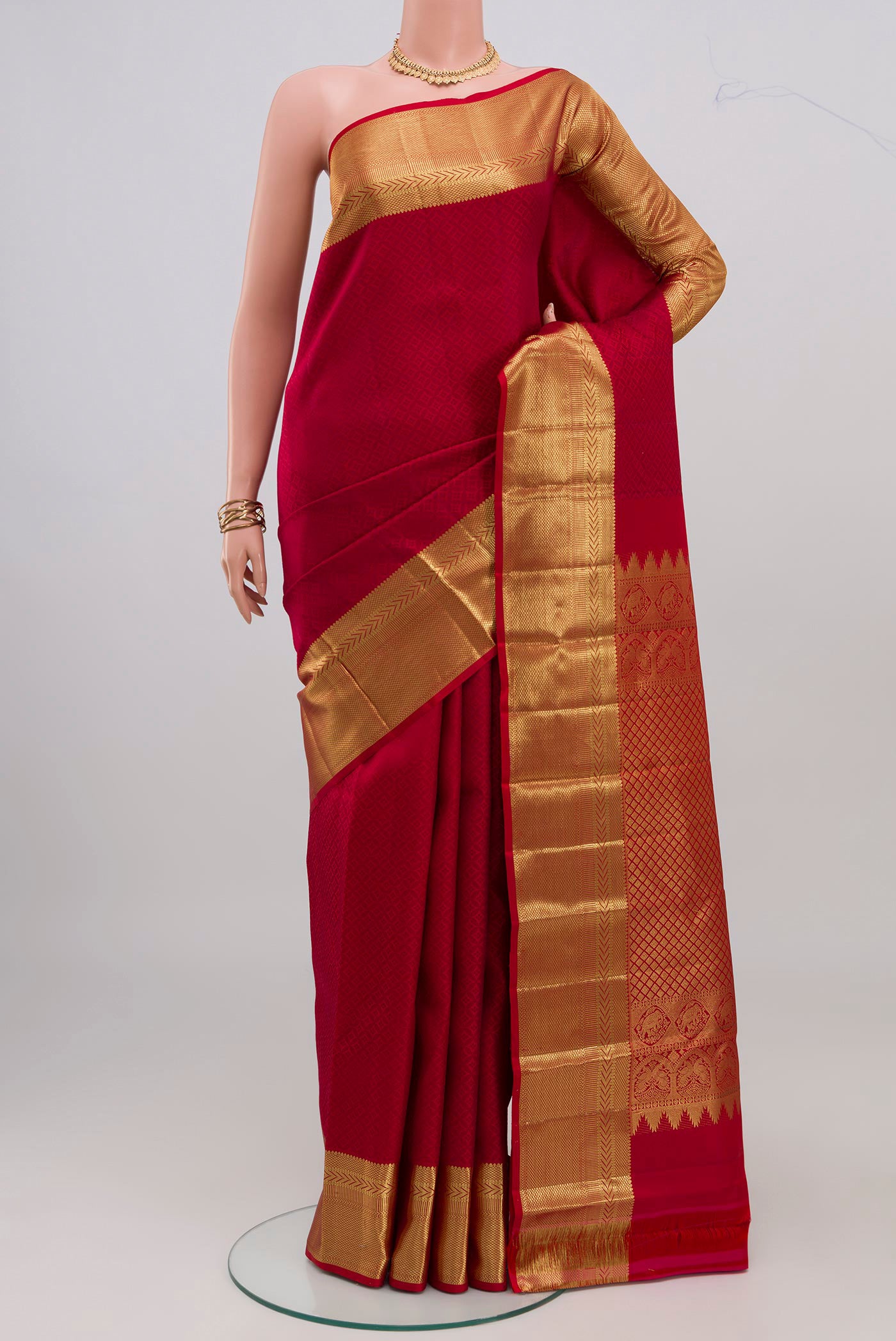 Red Kanjivaram Silk Saree with Jacquard design on the body and Zari Border.  displayed on a mannequin