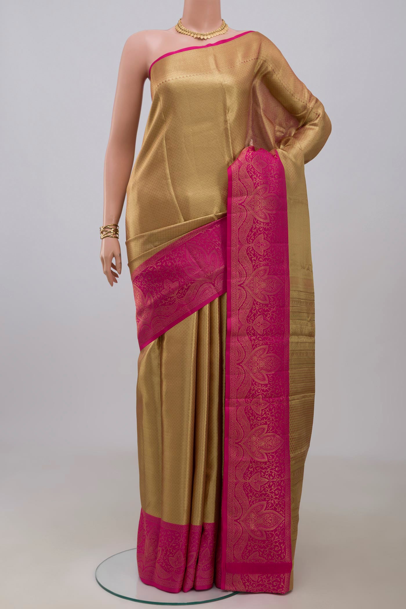 Golden Kanchipuram Silk Saree with Zari Brocade on the body and Fancy Border.  displayed on a mannequin