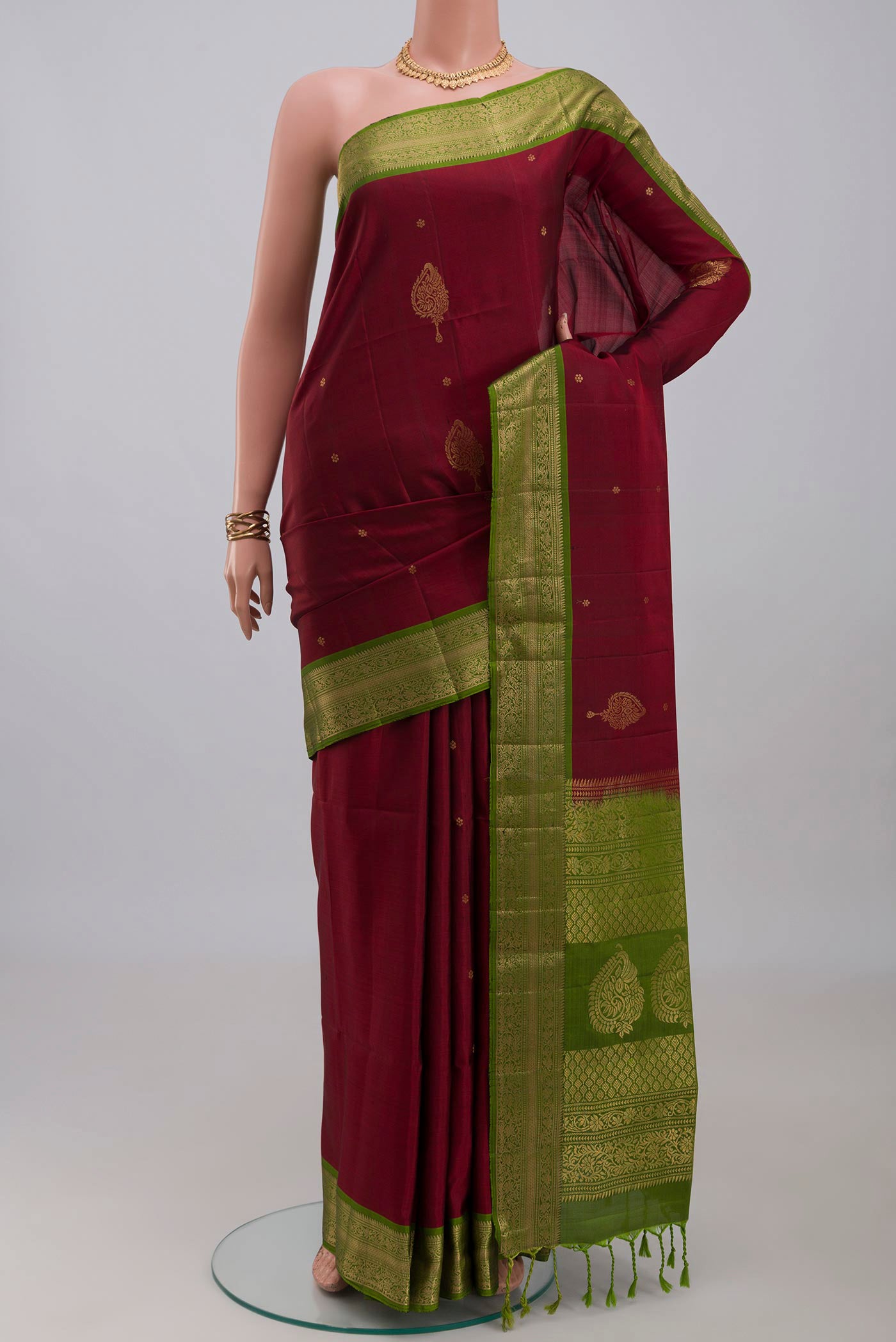 Maroon Soft Silk Saree with Zari Butta on the body and Zari Border.  displayed on a mannequin