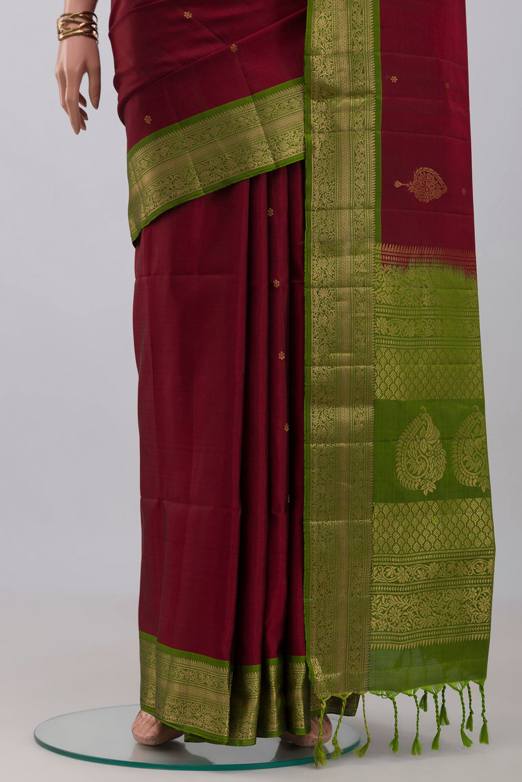 Pleats and pallu of Maroon Soft Silk Saree with Zari Butta on the body and Zari Border. 