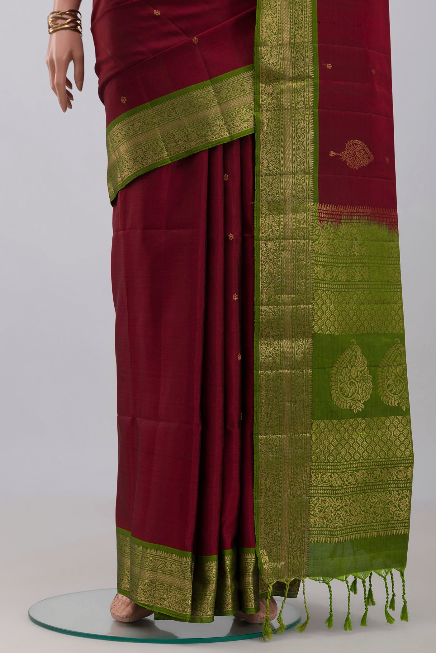 Pleats and pallu of Maroon Soft Silk Saree with Zari Butta on the body and Zari Border. 