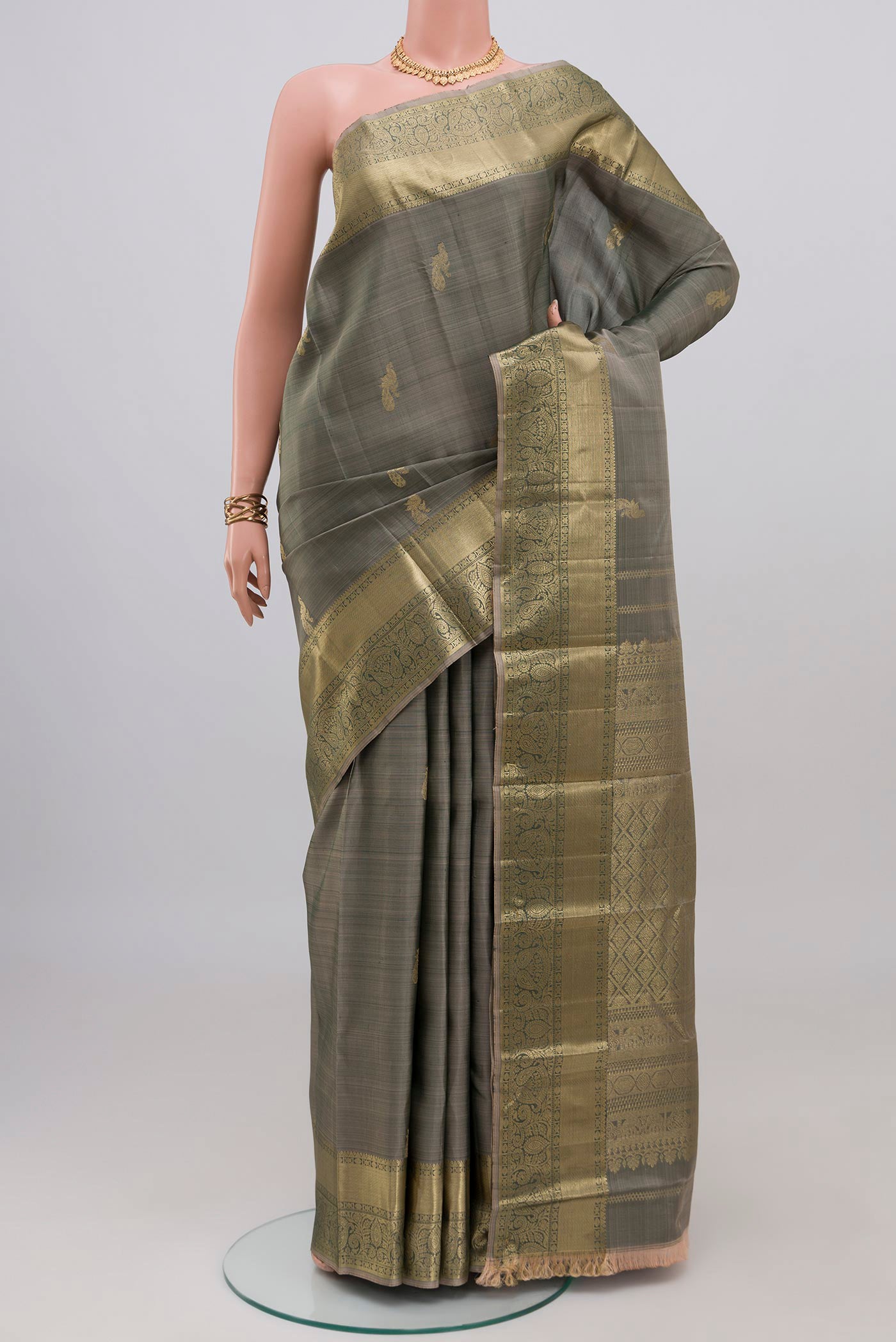 Grey Kanchipuram Silk Saree with Zari Butta on the body and Zari Border.  displayed on a mannequin