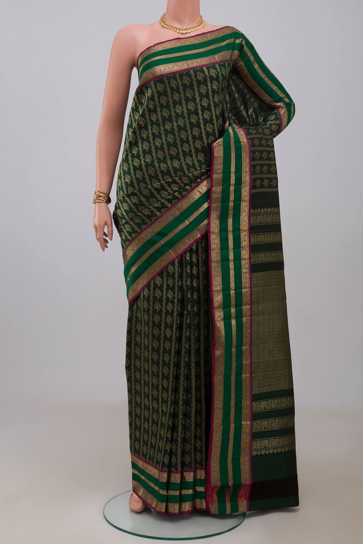Bottle Green Kanjivaram Silk Saree with Zari Brocade on the body and Zari Border.  displayed on a mannequin