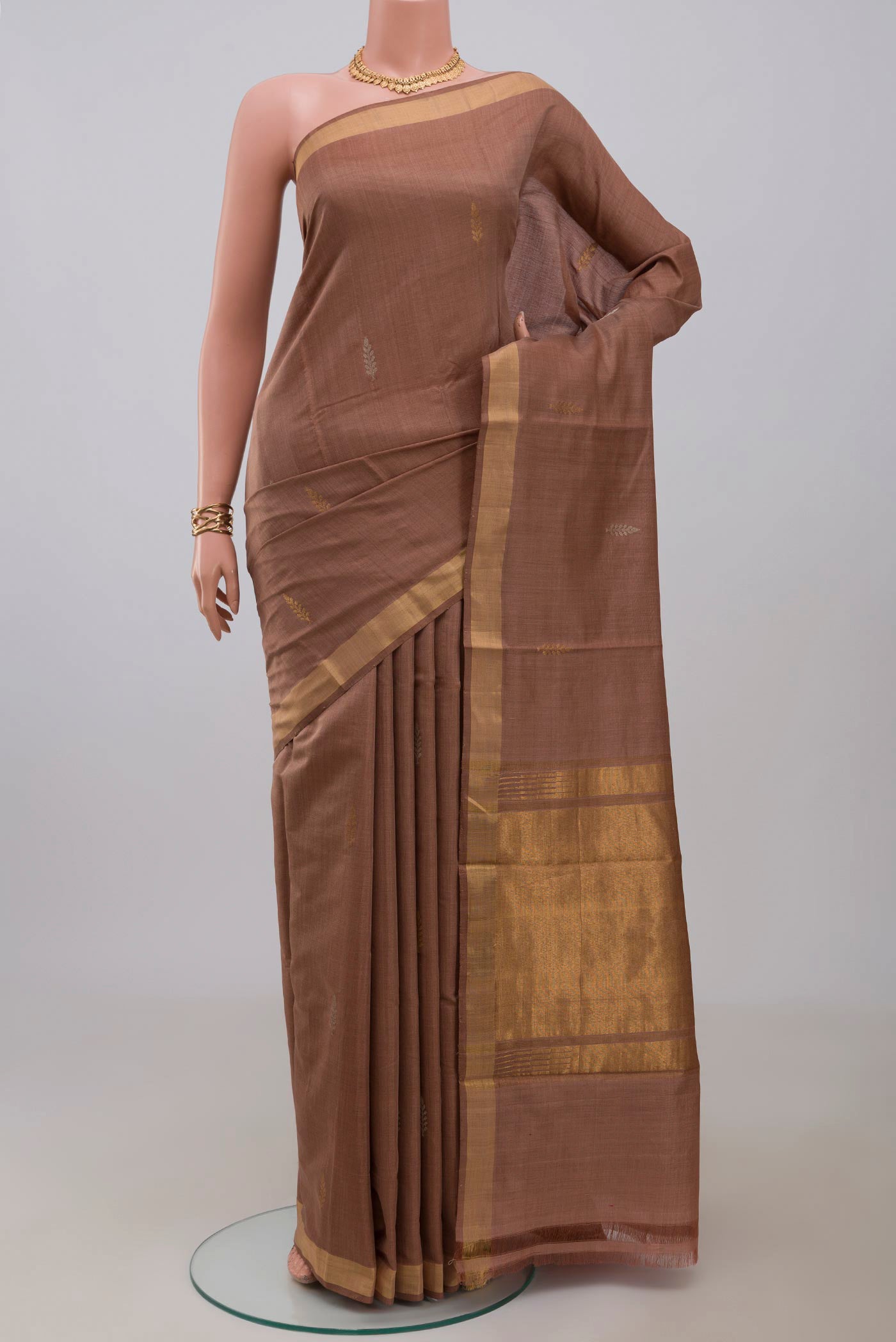 Brown Tussar Silk Saree with Zari Butta on the body and Zari Border.  displayed on a mannequin