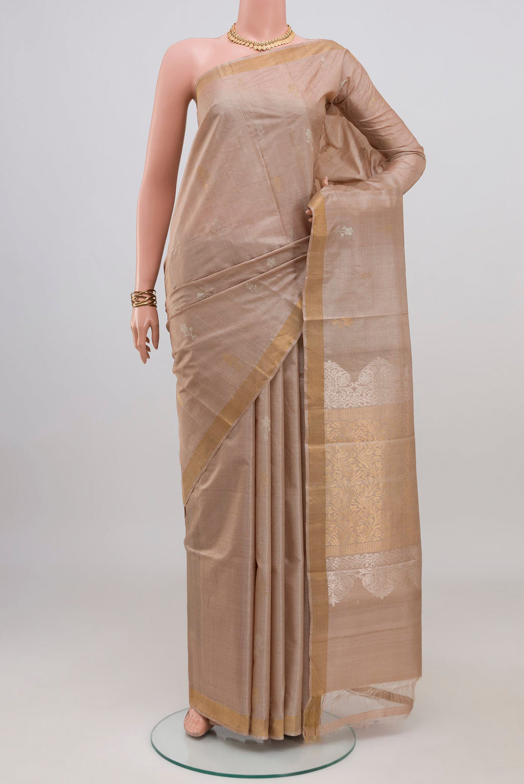 Beige Tussar Silk Saree with Zari Butta on the body and Thin Zari Line.  displayed on a mannequin