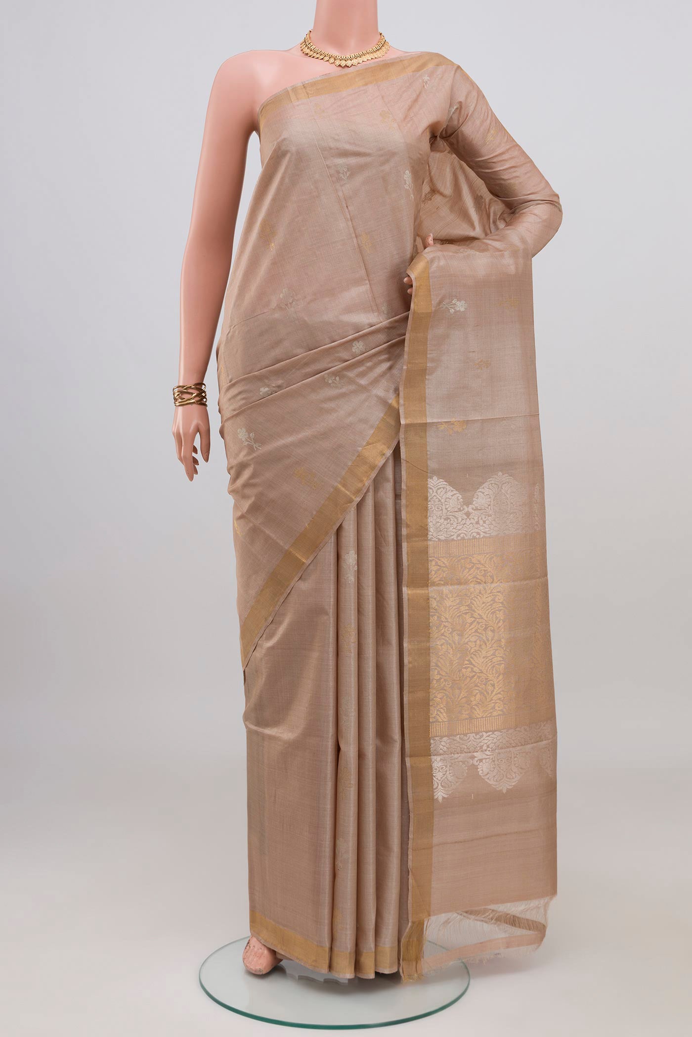 Beige Tussar Silk Saree with Zari Butta on the body and Thin Zari Line.  displayed on a mannequin