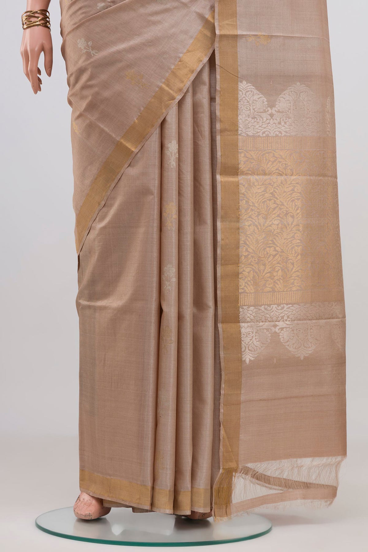 Pleats and pallu of Beige Tussar Silk Saree with Zari Butta on the body and Thin Zari Line. 