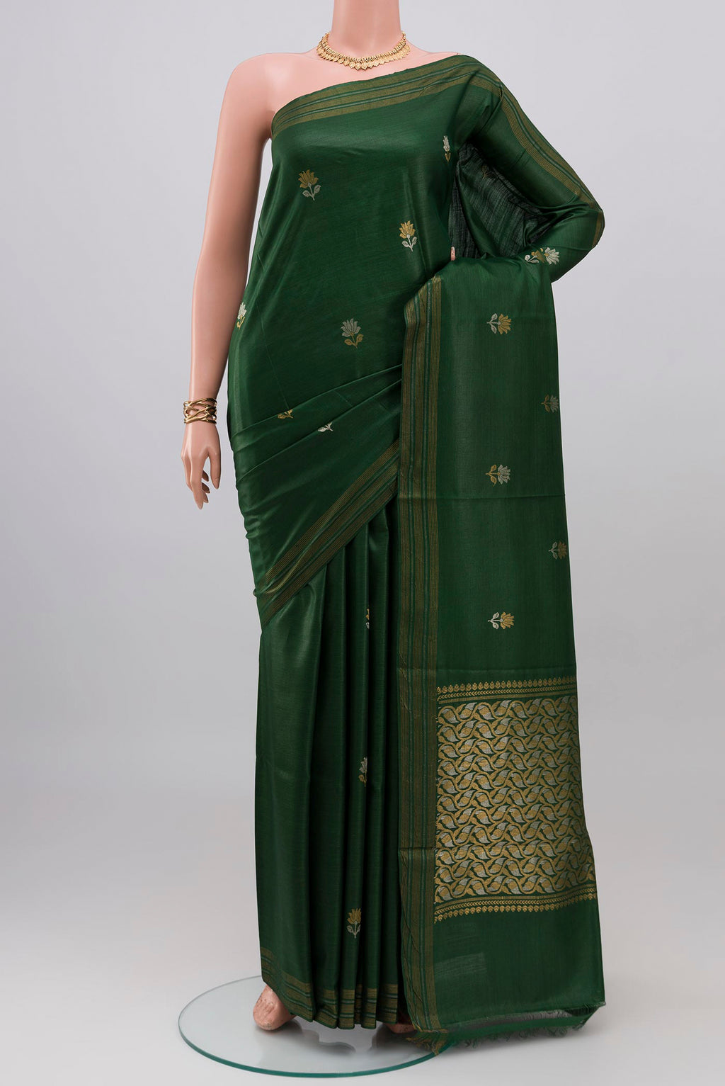 Bottle Green Tussar Silk Saree with Zari Butta on the body and Zari Border.  displayed on a mannequin