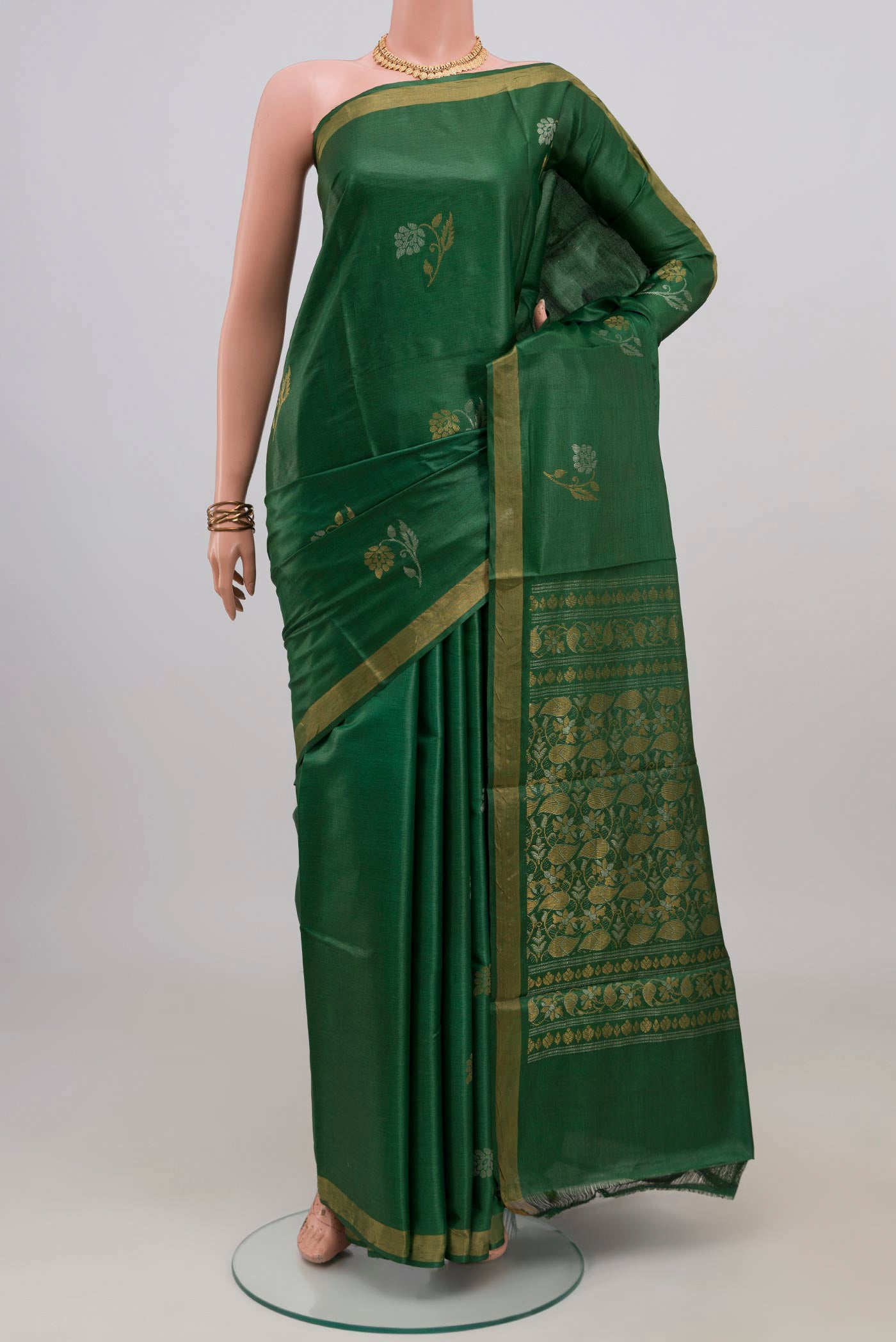Green Tussar Silk Saree with Zari Butta on the body and Zari Border.  displayed on a mannequin