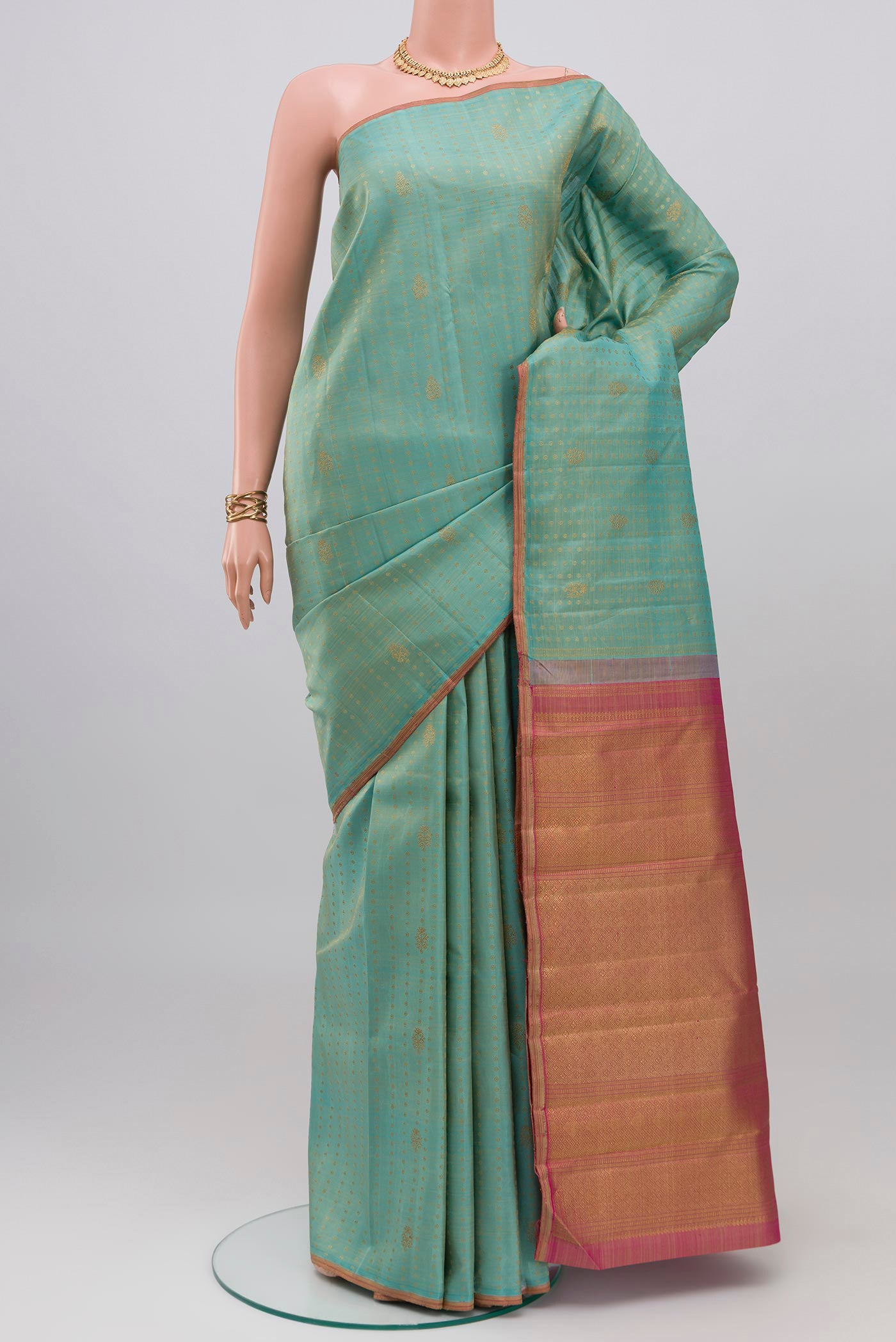 Pure Silk Pure Zari Light Blue Kanchipuram Saree with Zari Butta on the body and Thin Zari Line.  displayed on a mannequin