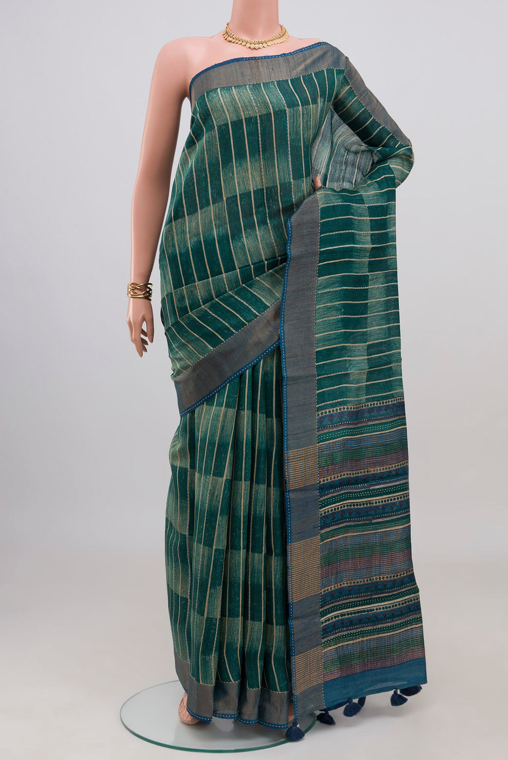Green Tussar Silk Saree with Printed design on the body and Zari Border.  displayed on a mannequin