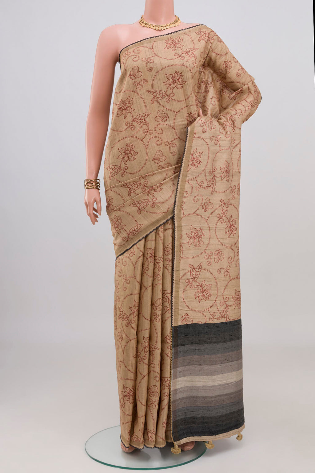 Sandal Tussar Silk Saree with Printed design on the body and Thin Zari Line.  displayed on a mannequin