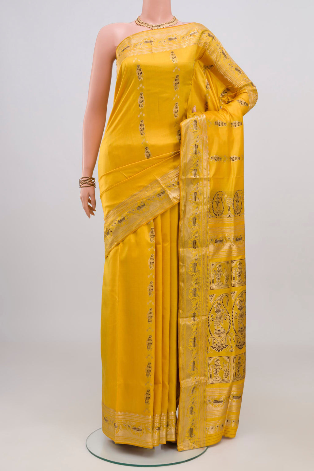 Yellow Baluchari Silk Saree with Zari And Thread Butta on the body and Zari Border.  displayed on a mannequin
