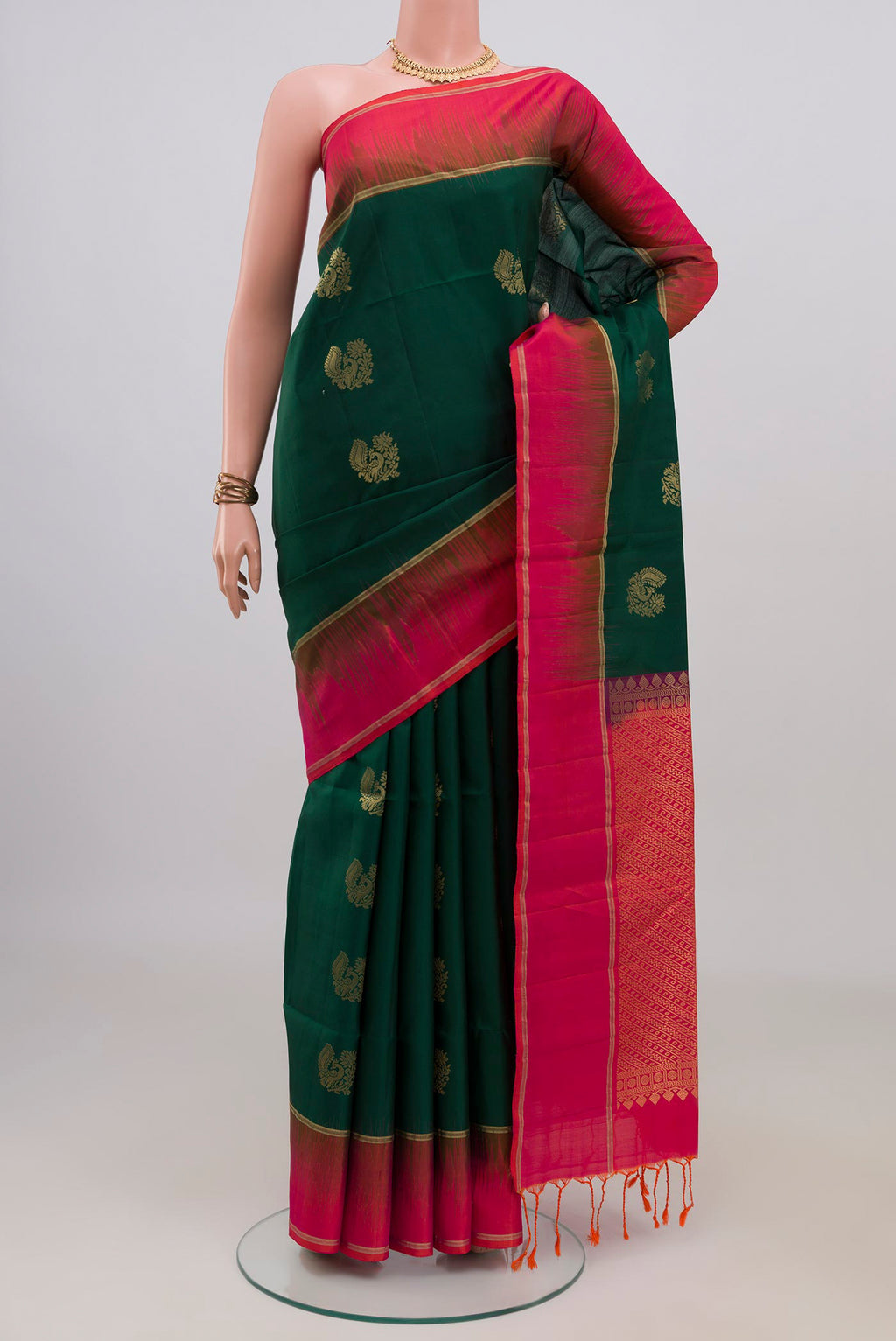 Pure Silk Bottle Green Soft Saree with Zari Butta on the body and Plain Border.  displayed on a mannequin