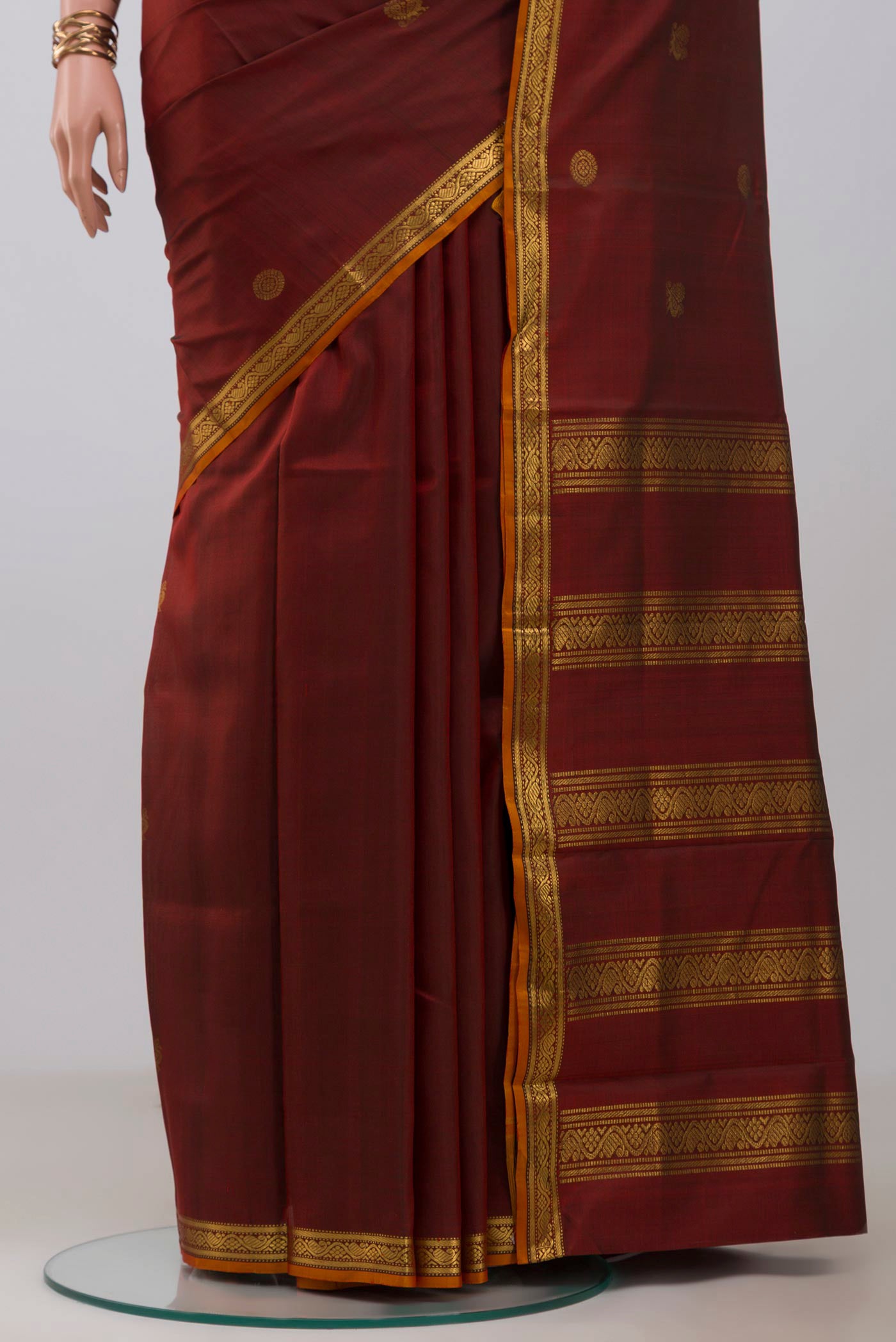Pleats and pallu of Maroon Kanchipuram Silk Saree with Zari Butta on the body and Zari Border. 