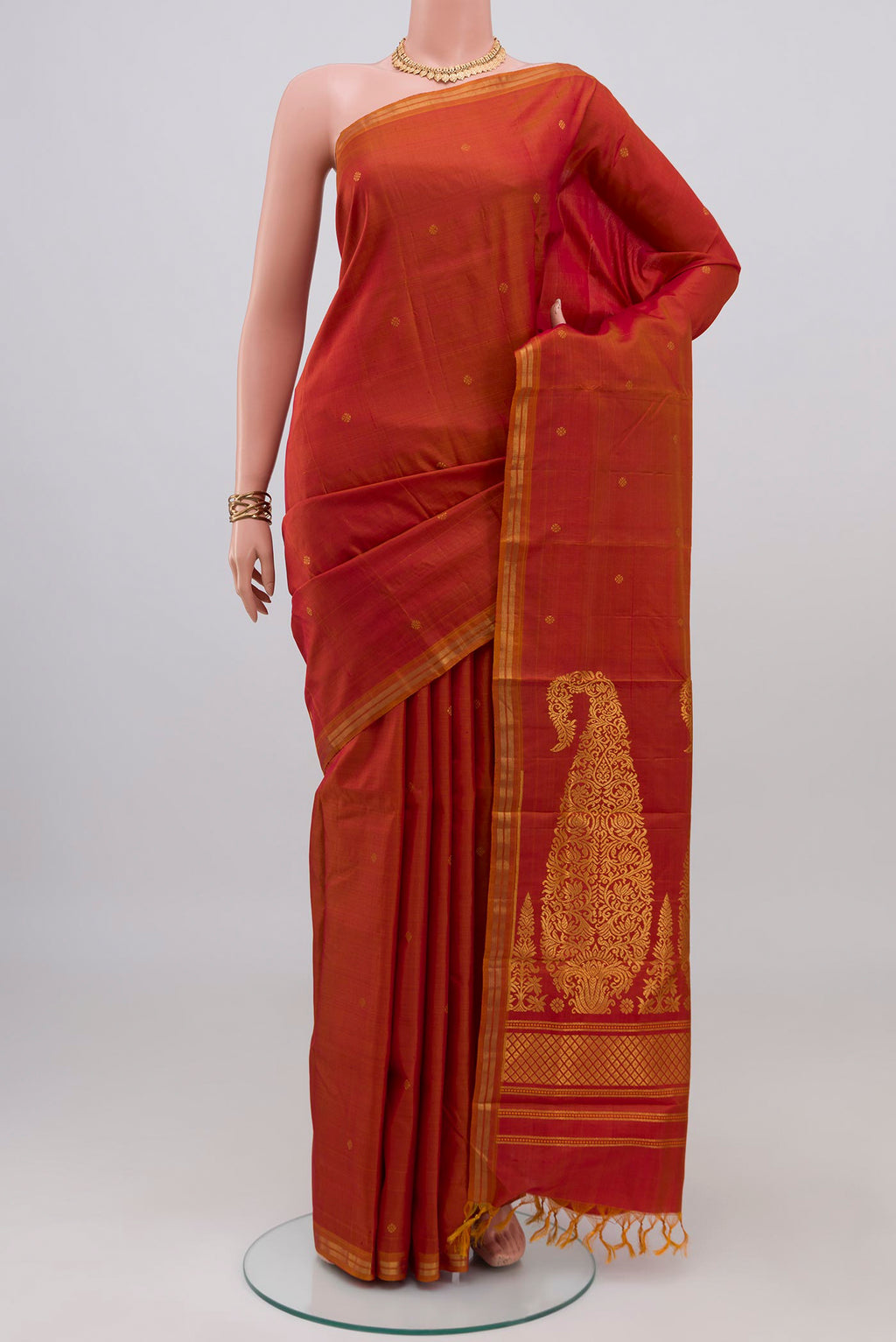 Brick Orange Dual Tone Kanchipuram Silk Saree with Zari Butta on the body and Thin Zari Line.  displayed on a mannequin
