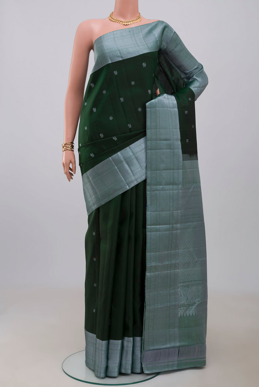 Bottle Green Kanchipuram Silk Saree with Thread Butta on the body and Thread Border.  displayed on a mannequin