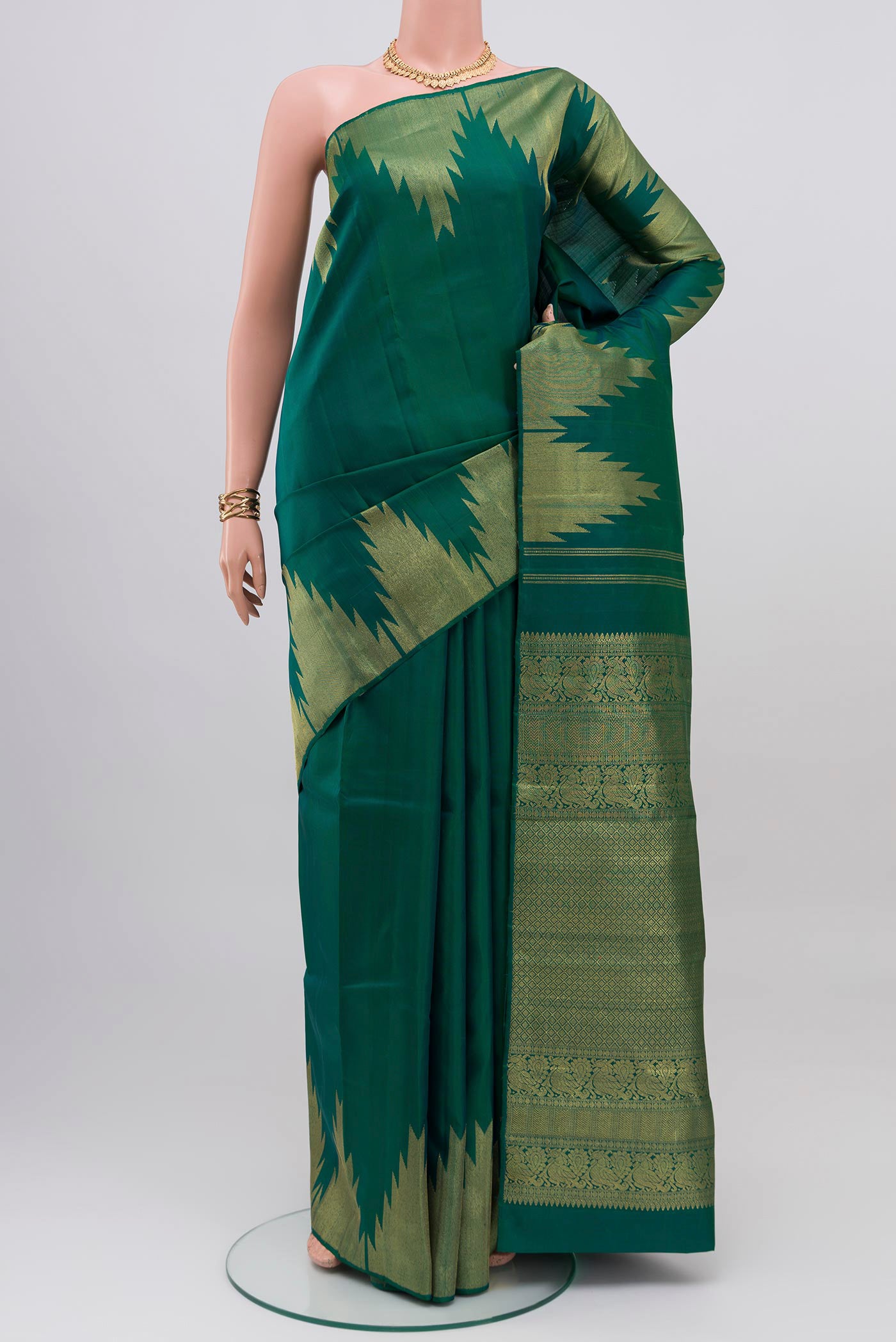 Green Kanchipuram Saree with Plain Body and Temple Border.  displayed on a mannequin