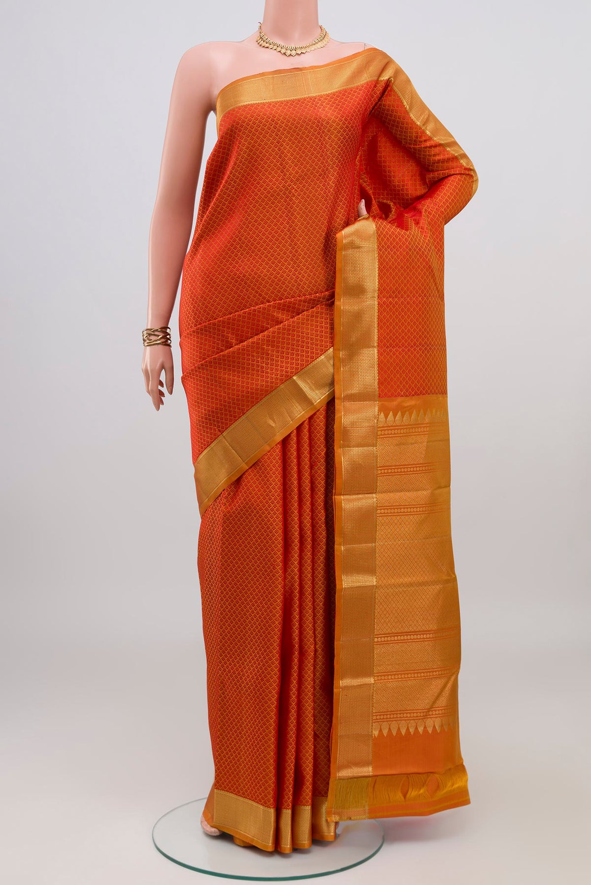 Brick Orange Kanjivaram Silk Saree with Jacquard design on the body and Zari Border.  displayed on a mannequin