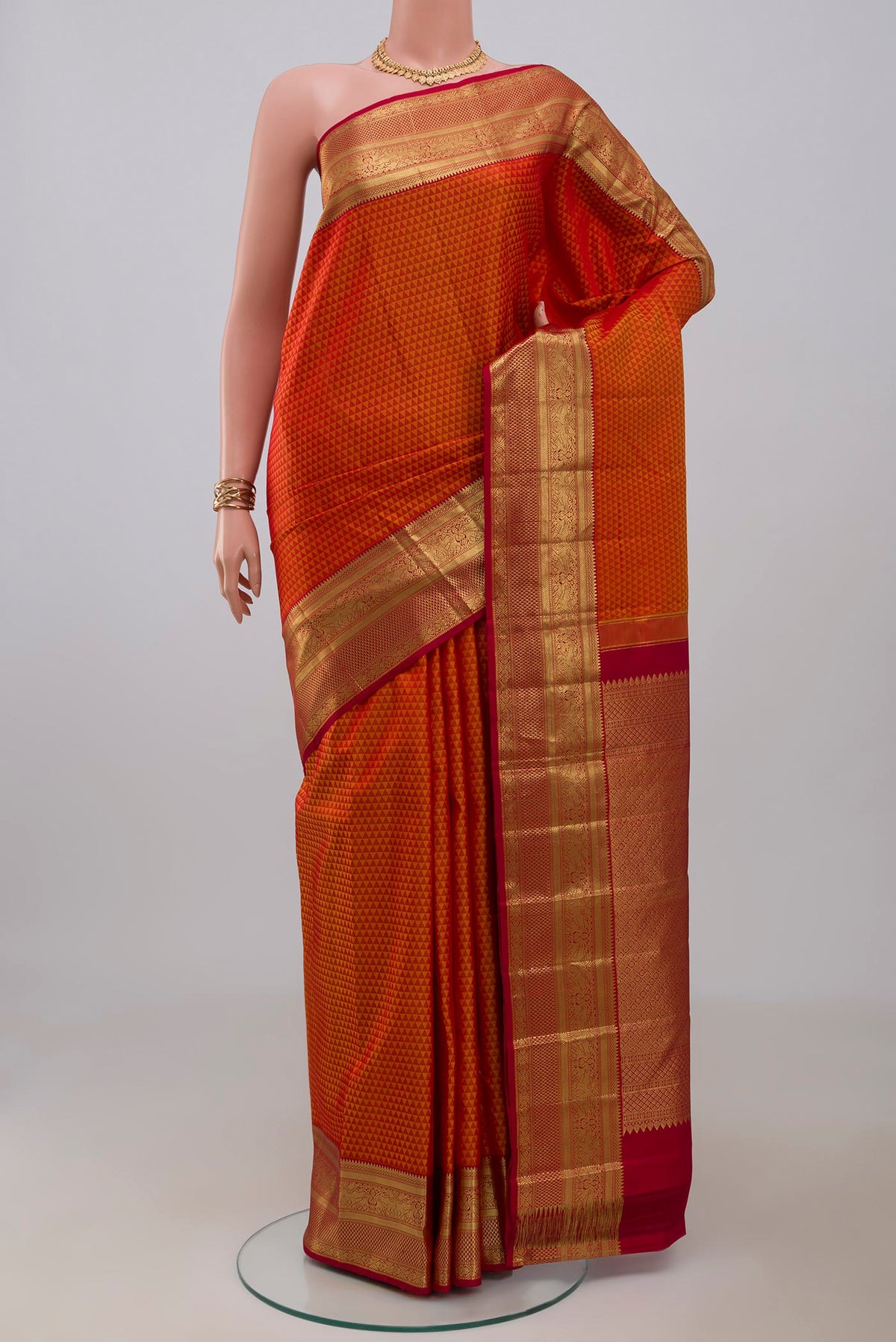 Orange Kanjivaram Silk Saree with Jacquard design on the body and Zari Border.  displayed on a mannequin