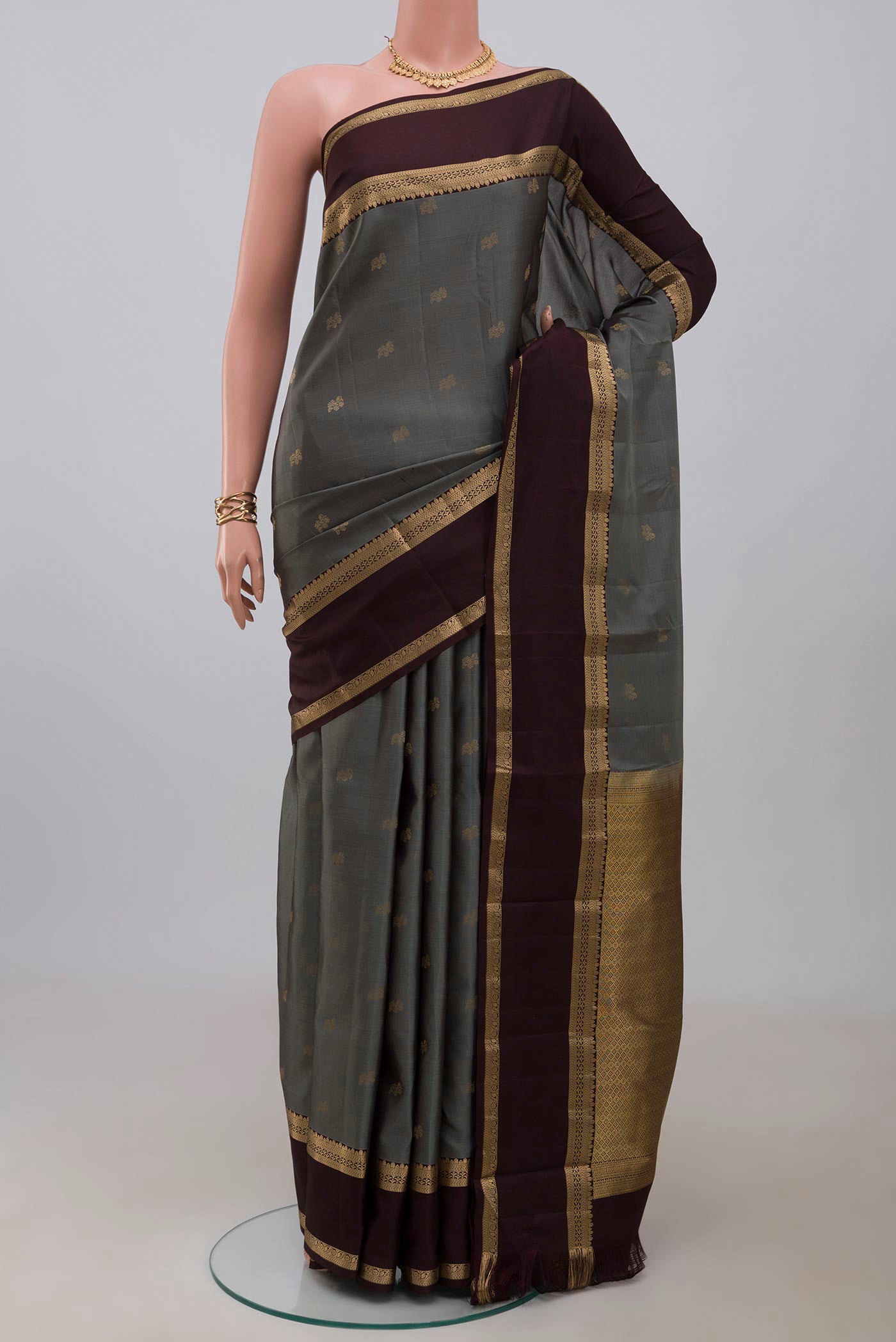 Grey Kanchipuram Silk Saree with Zari Butta on the body and Zari Border.  displayed on a mannequin