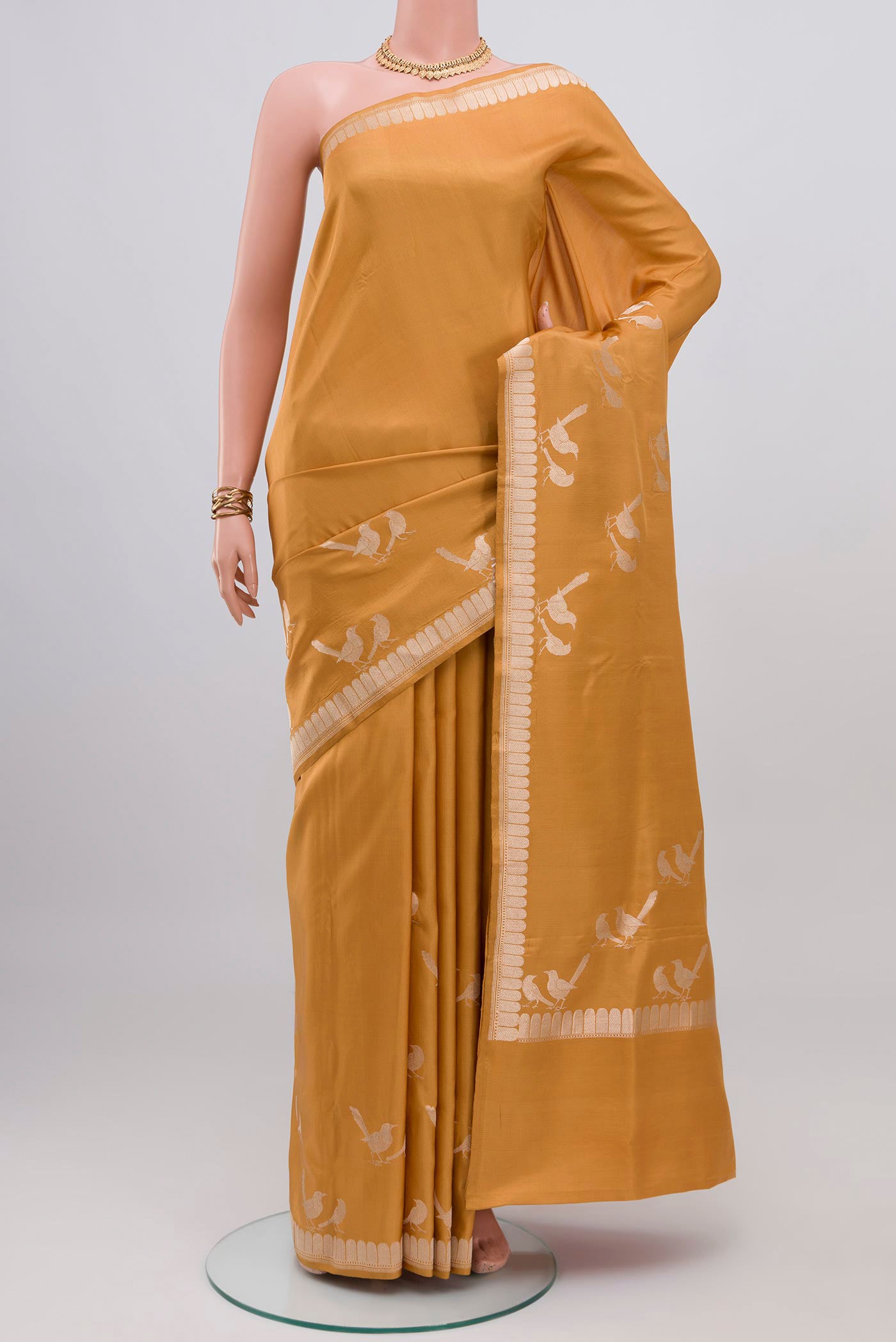 Caramel Banarasi Silk Saree with Plain Body and Zari Border.  displayed on a mannequin