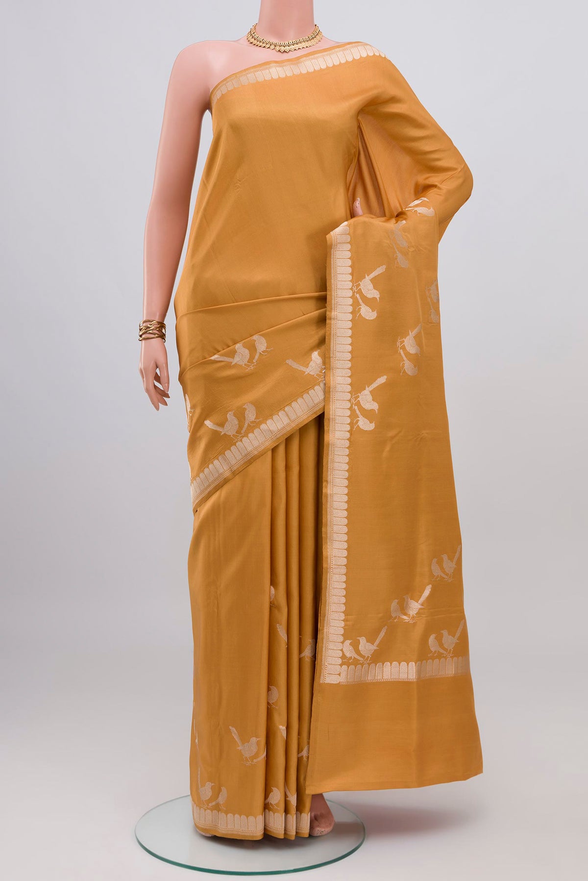 Caramel Banarasi Silk Saree with Plain Body and Zari Border.  displayed on a mannequin