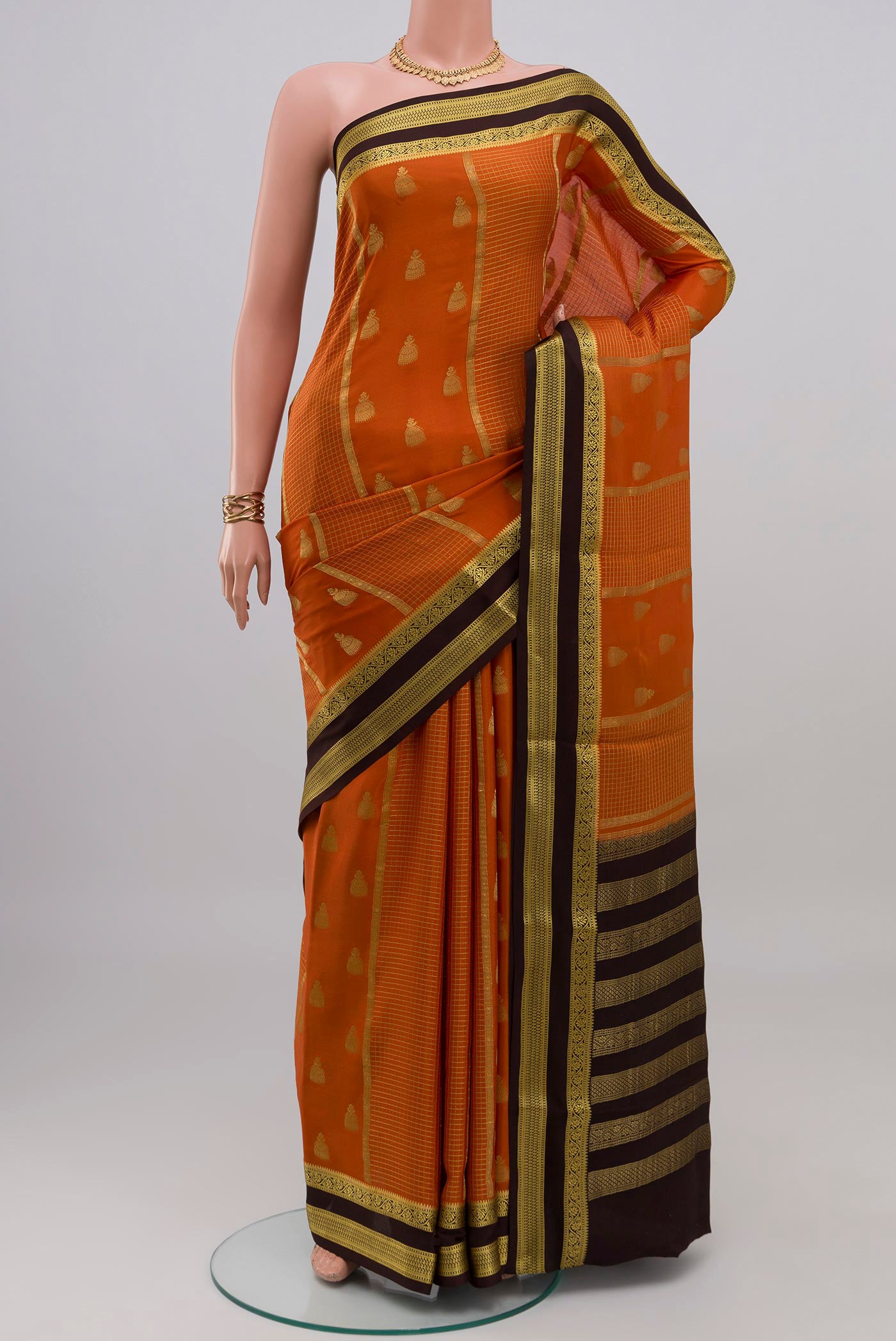 Orange Mysore Crepe Saree with Zari Butta on the body and Zari Border.  displayed on a mannequin