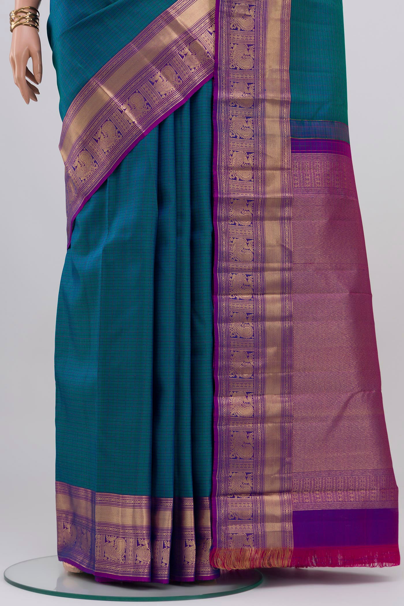 Pleats and pallu of Peacock Blue Kanchipuram Saree with Checked design on the body and Zari Border. 