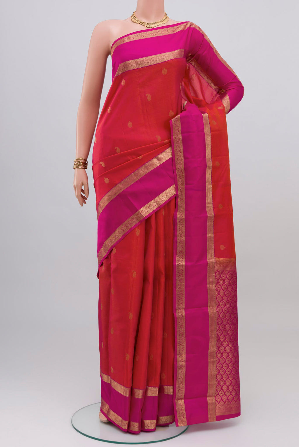 Pink with Orange Color Kanchipuram Silk Saree with Zari Butta on the body and Zari Border.  displayed on a mannequin