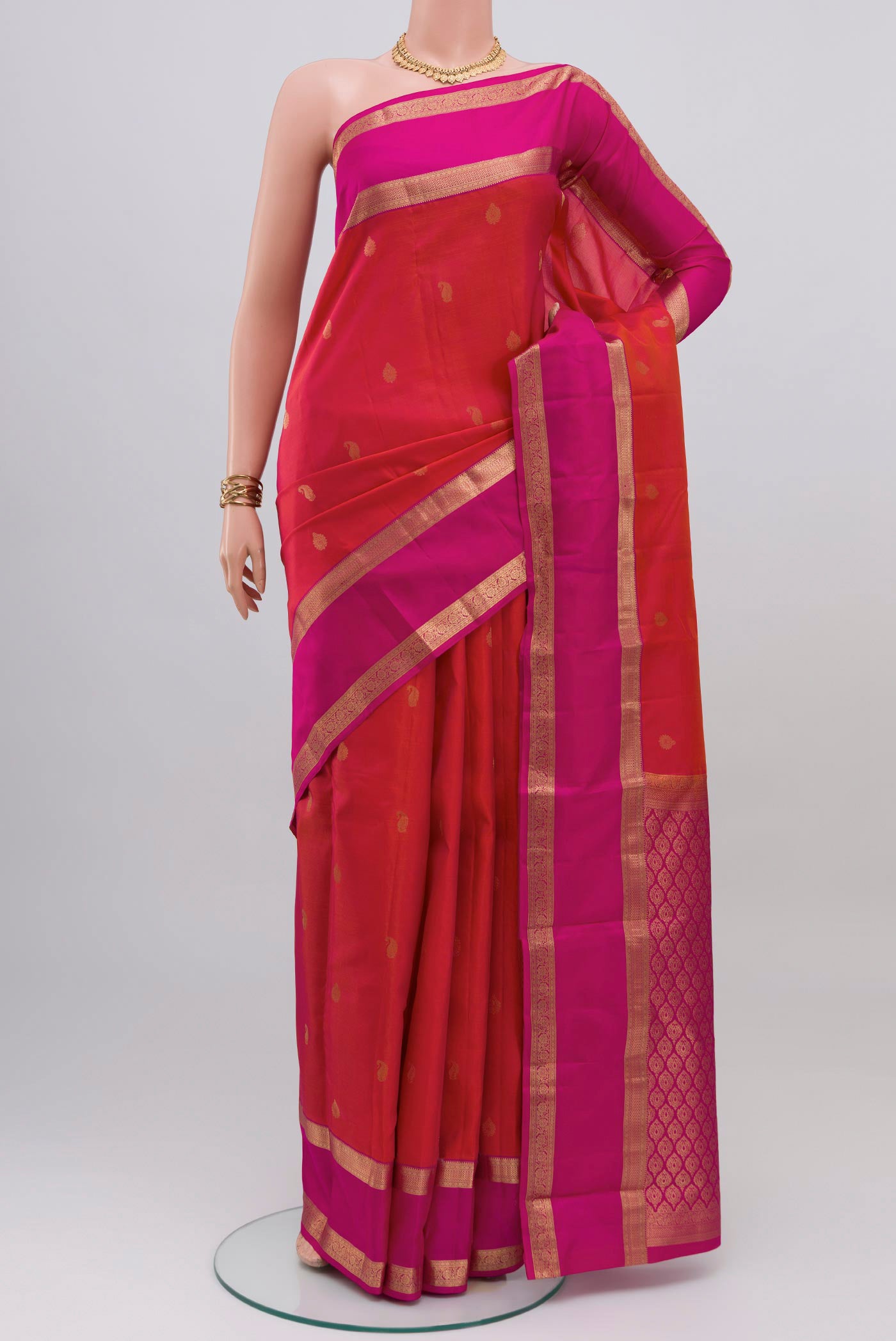 Pink with Orange Color Kanchipuram Silk Saree with Zari Butta on the body and Zari Border.  displayed on a mannequin