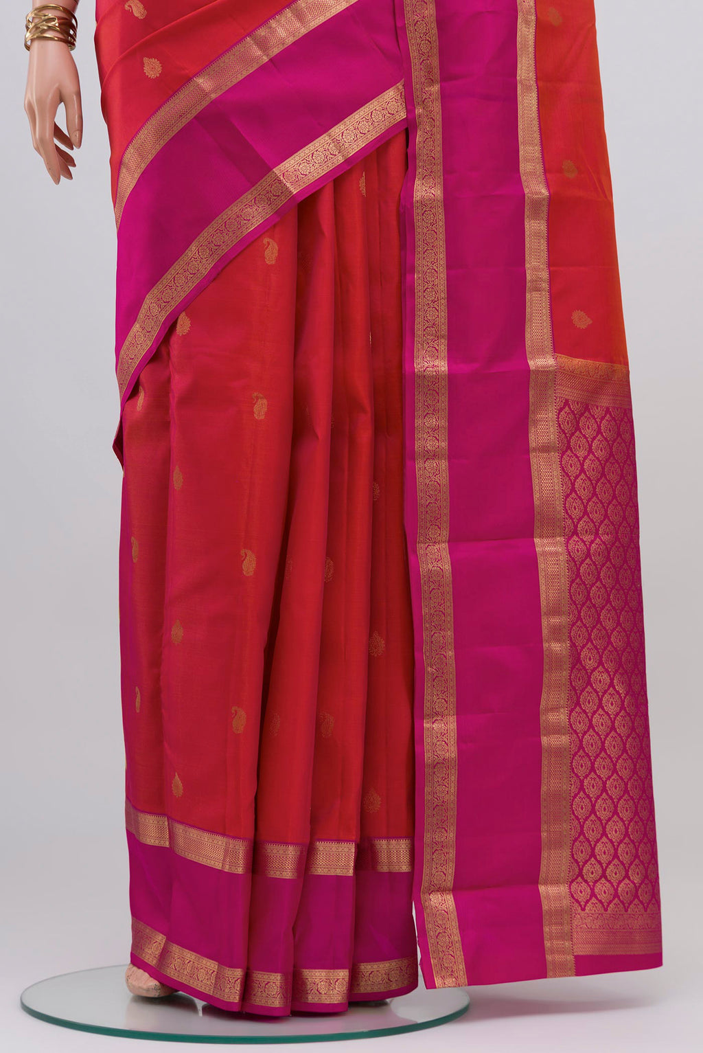 Pleats and pallu of Pink with Orange Color Kanchipuram Silk Saree with Zari Butta on the body and Zari Border. 