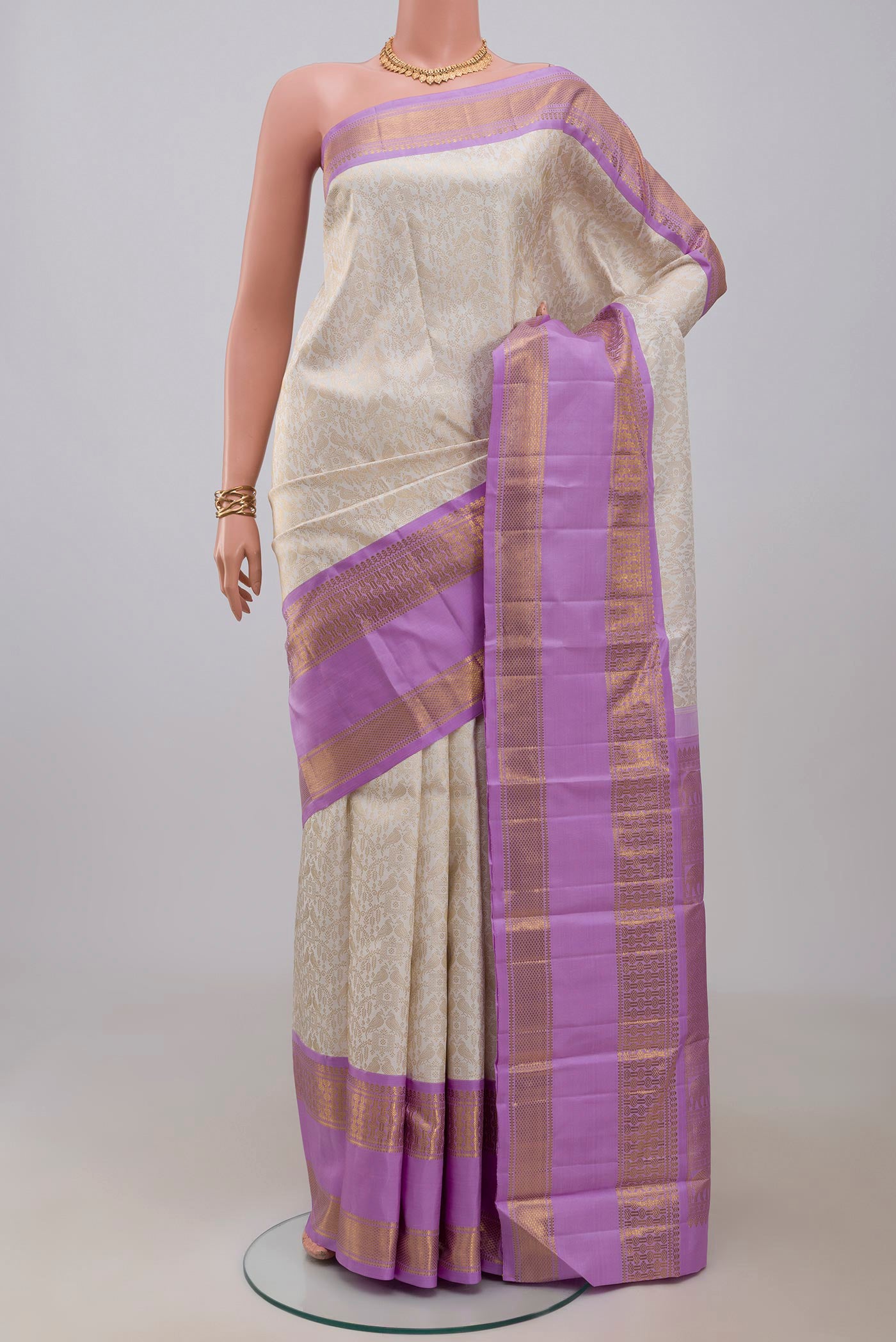 Off White Kanchipuram Silk Saree with Zari Brocade on the body and Zari Border.  displayed on a mannequin