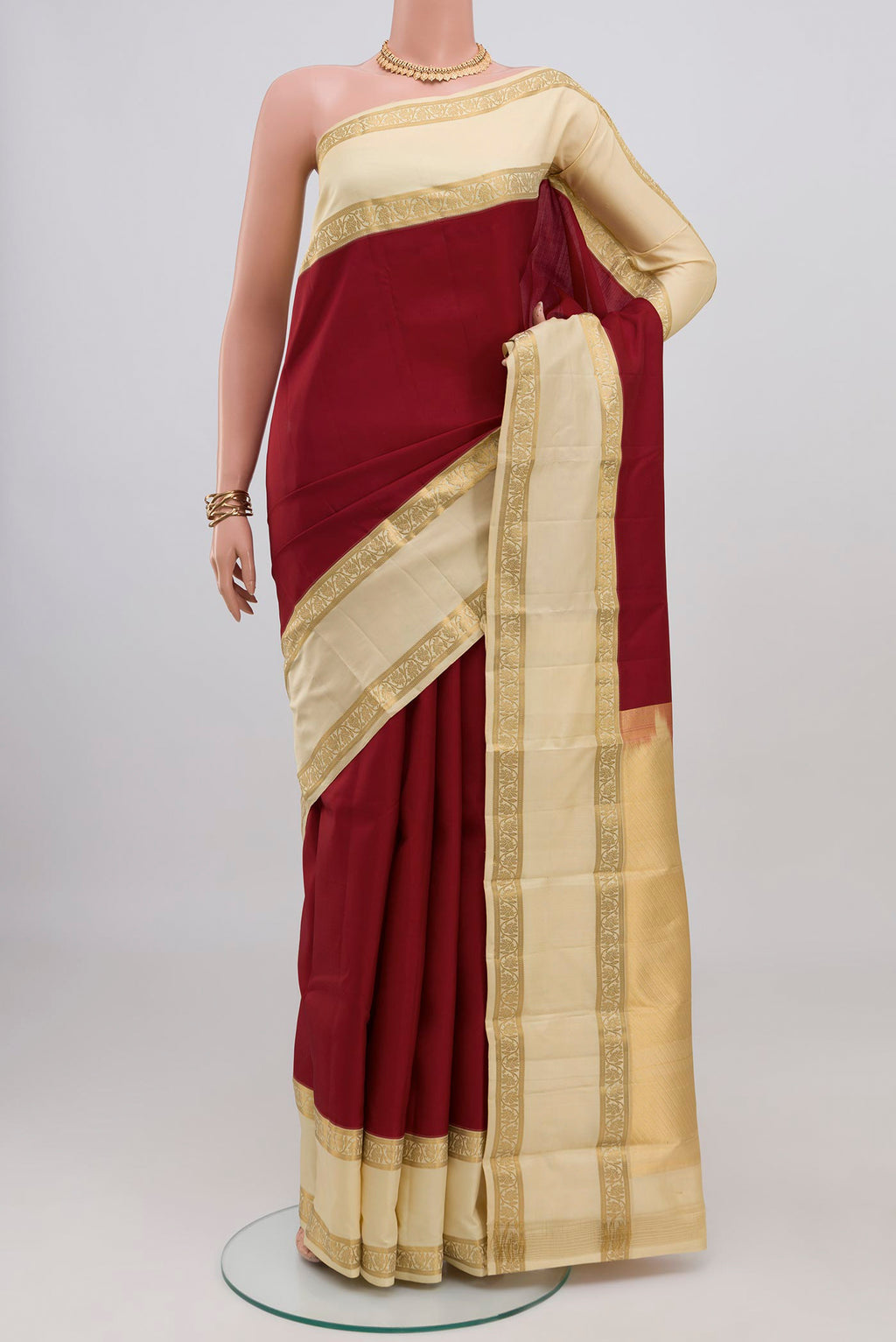 Maroon Kanchipuram Silk Saree with Plain Body and Zari Border.  displayed on a mannequin
