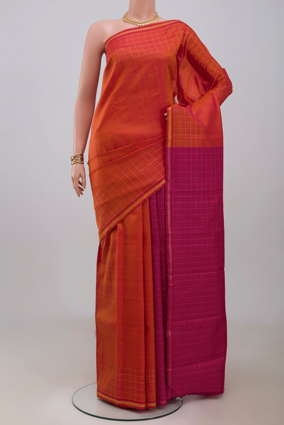 Pure Silk Pure Zari Brick Orange Kanchipuram Saree with Plain Body and Checks Border.  displayed on a mannequin