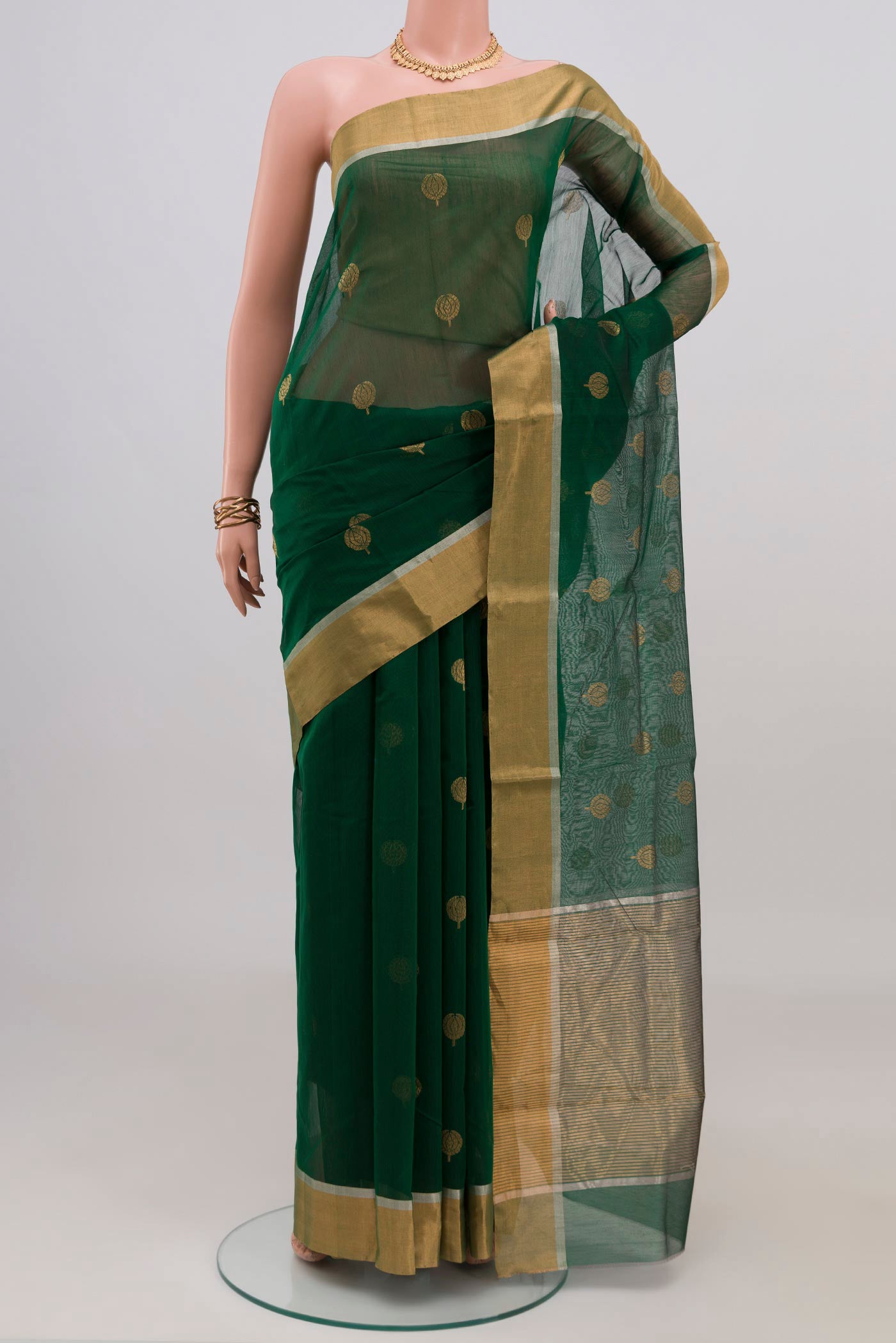 Bottle Green Chanderi Silk Cotton Saree with Zari Butta on the body and Zari Border.  displayed on a mannequin