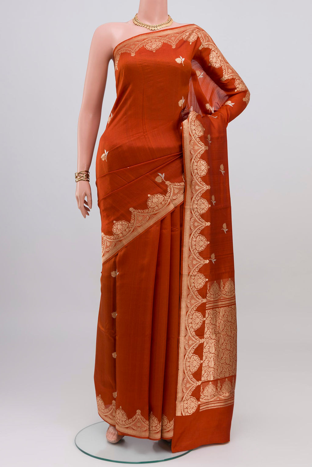 Rust Banarasi Katan Silk Saree with Zari Butta on the body and Fancy Border.  displayed on a mannequin