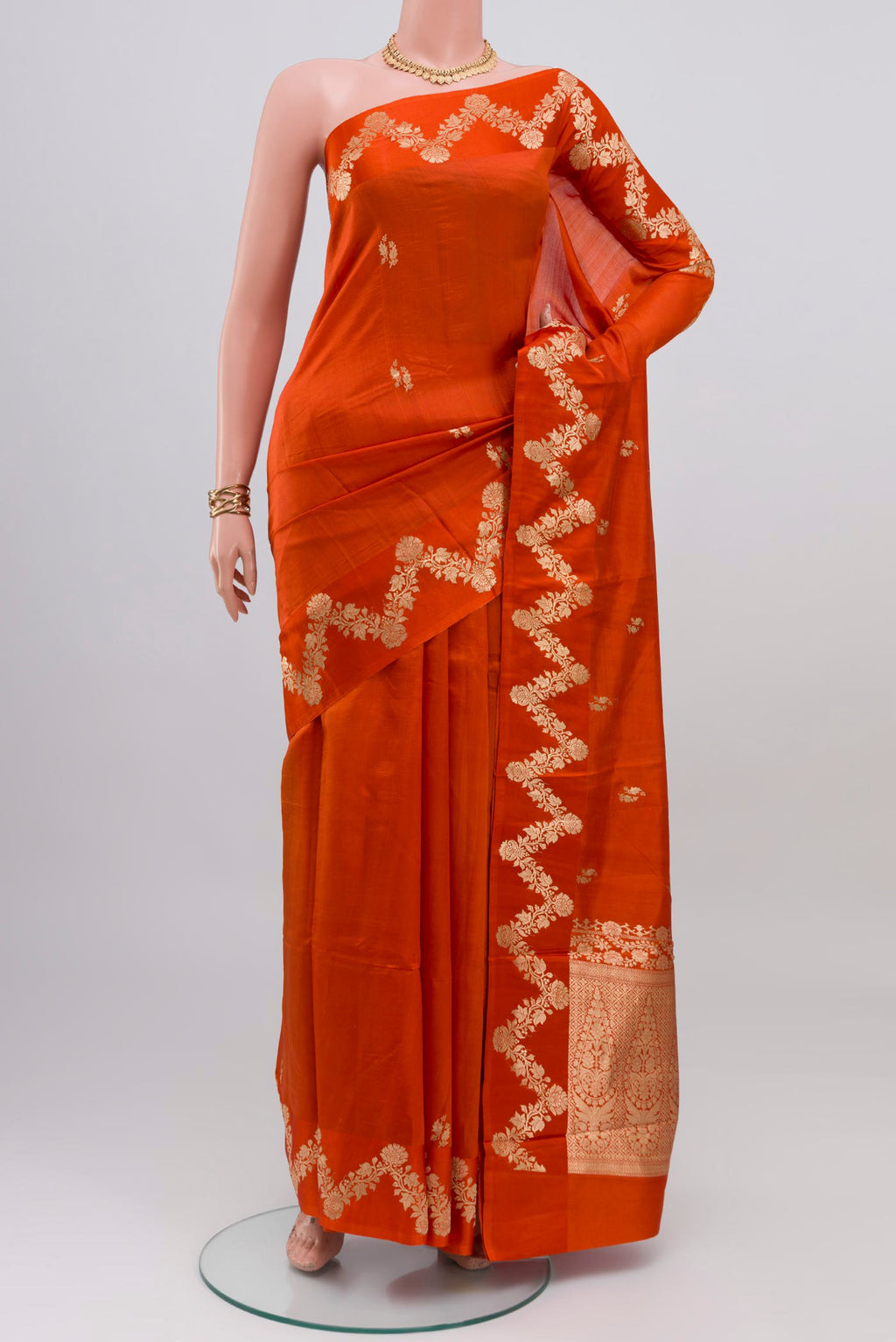 Orange Banarasi Katan Silk Saree with Zari Butta on the body and Fancy Border.  displayed on a mannequin