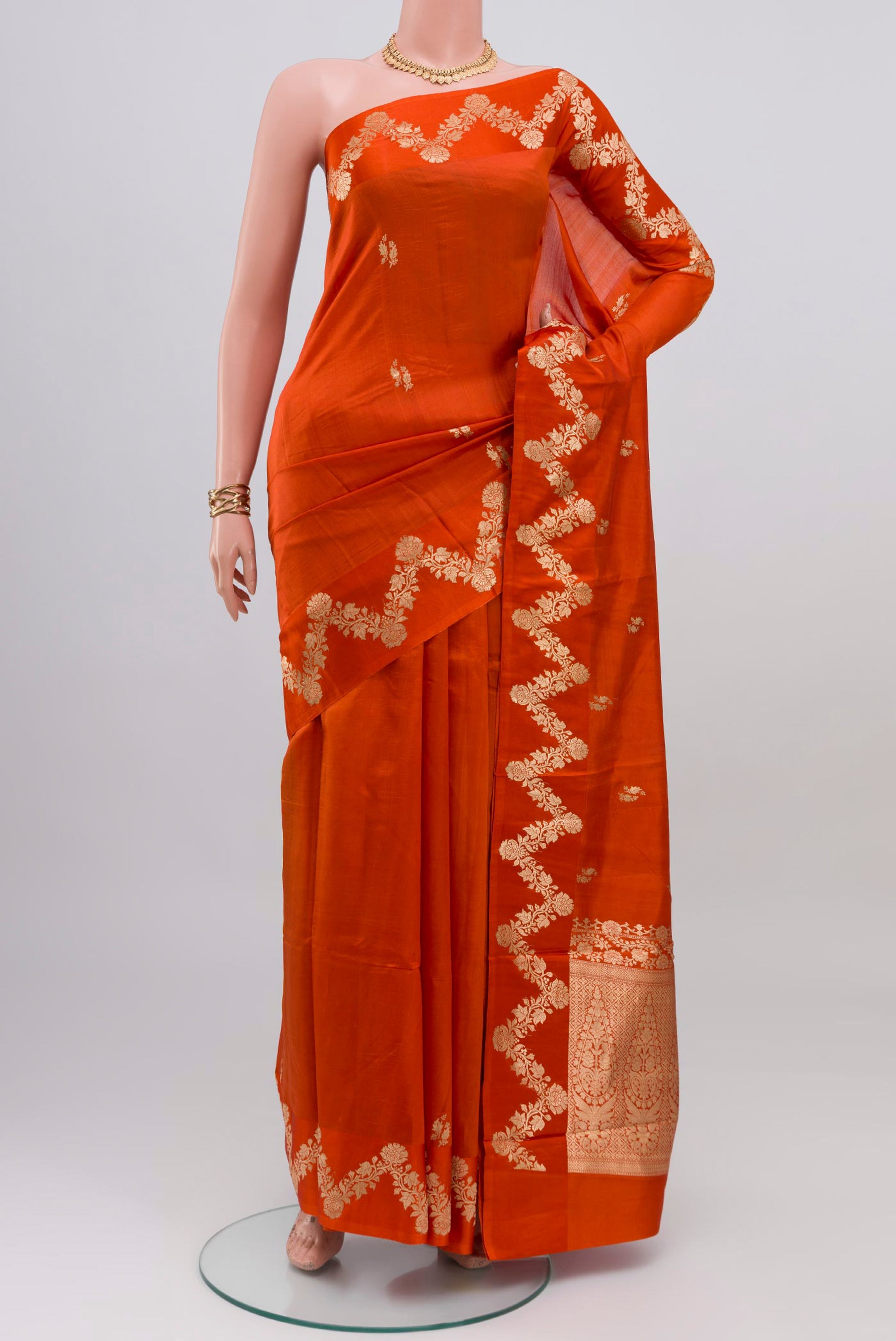 Orange Banarasi Katan Silk Saree with Zari Butta on the body and Fancy Border.  displayed on a mannequin