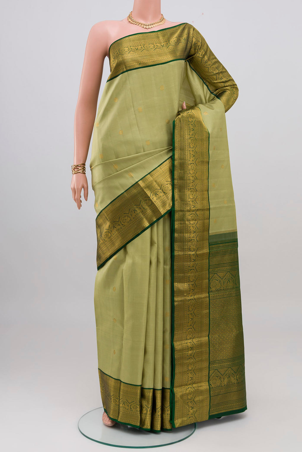 Light Green Kanchipuram Silk Saree with Zari Butta on the body and Zari Border.  displayed on a mannequin