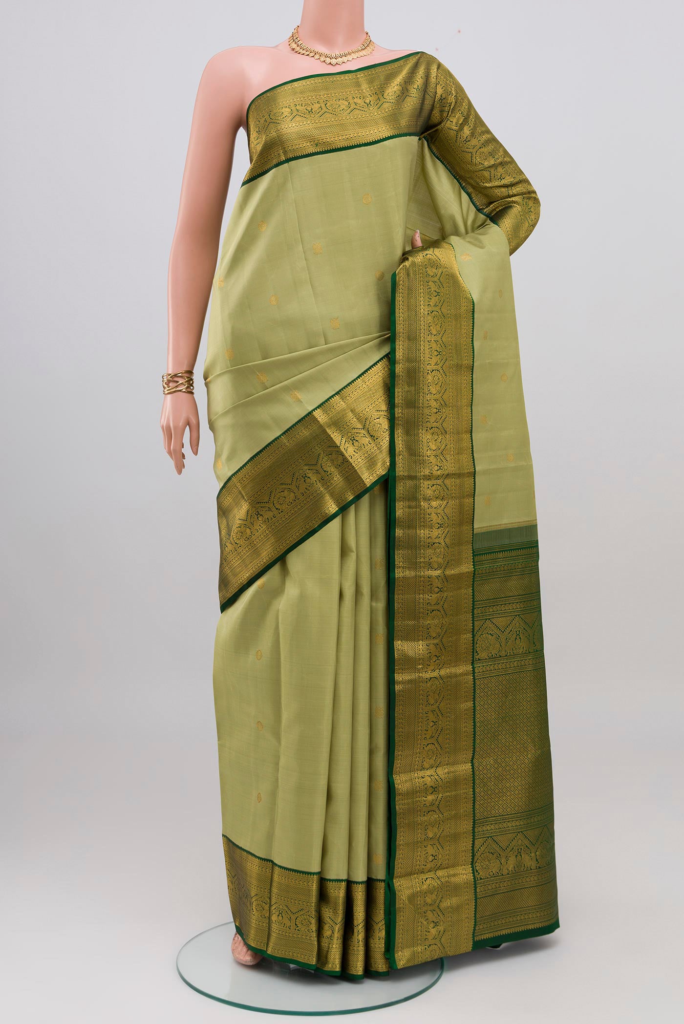 Light Green Kanchipuram Silk Saree with Zari Butta on the body and Zari Border.  displayed on a mannequin