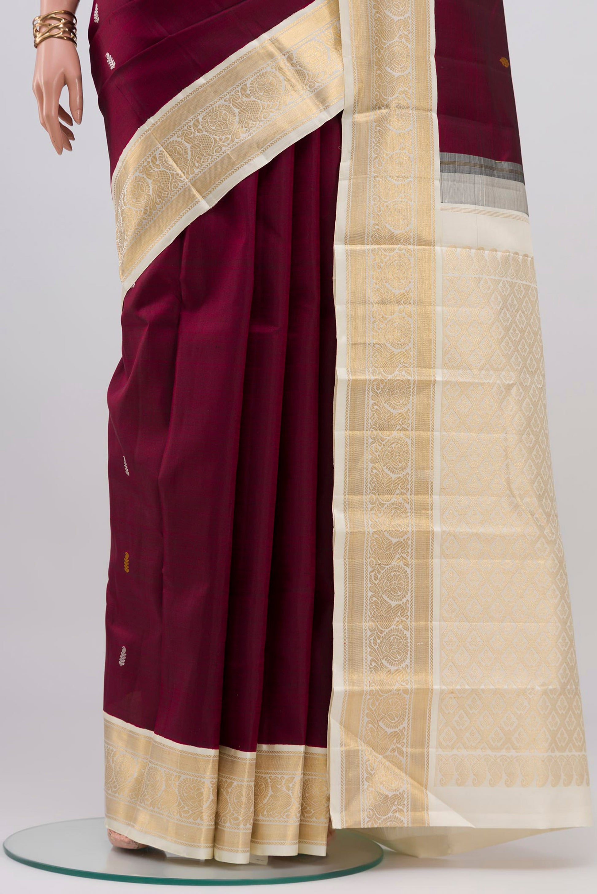Pleats and pallu of Maroon Kanjivaram Silk Saree with Thread Butta on the body and Ganga Jamuna Border. 