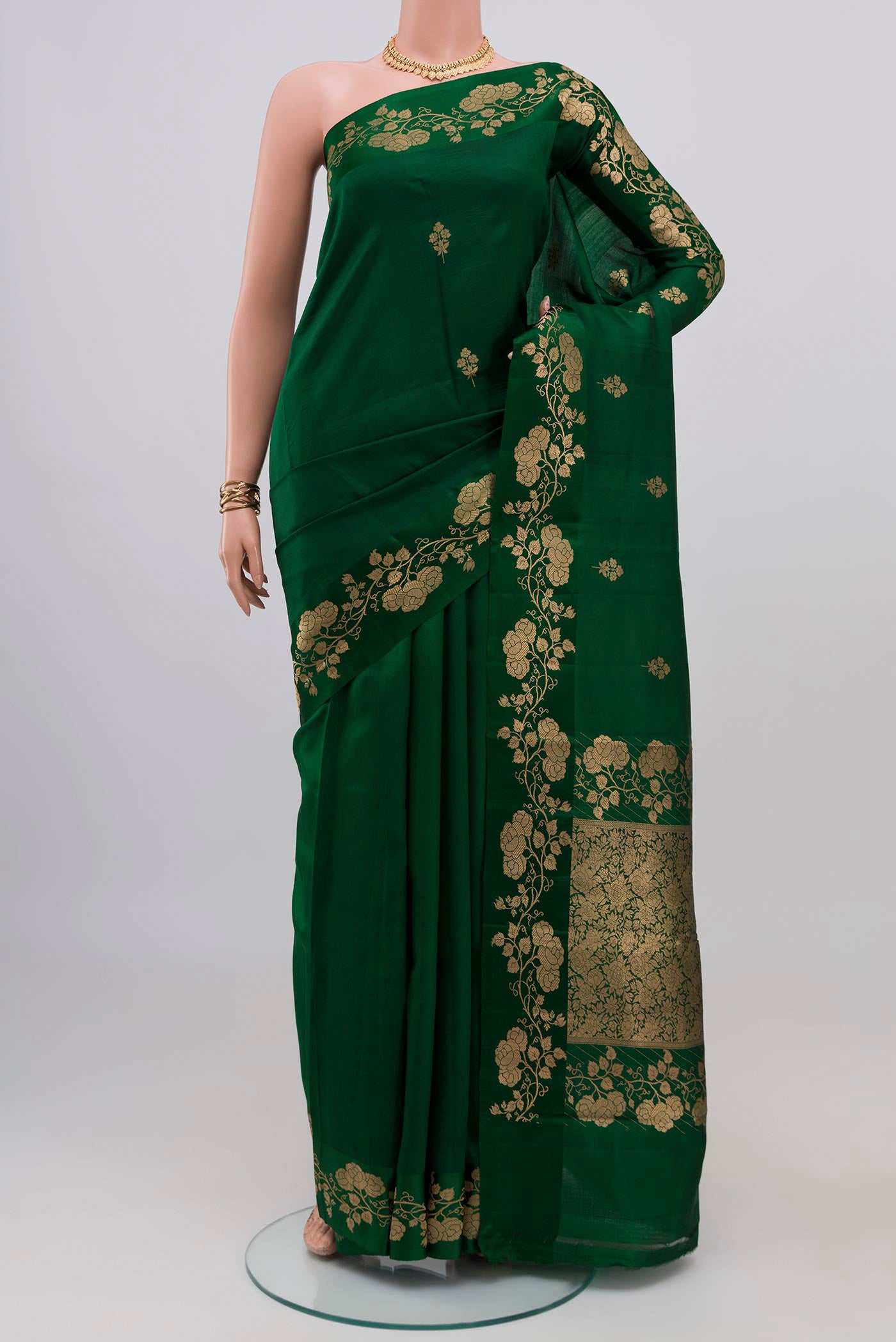Bottle Green Banarasi Katan Silk Saree with Zari Butta on the body and Fancy Border.  displayed on a mannequin