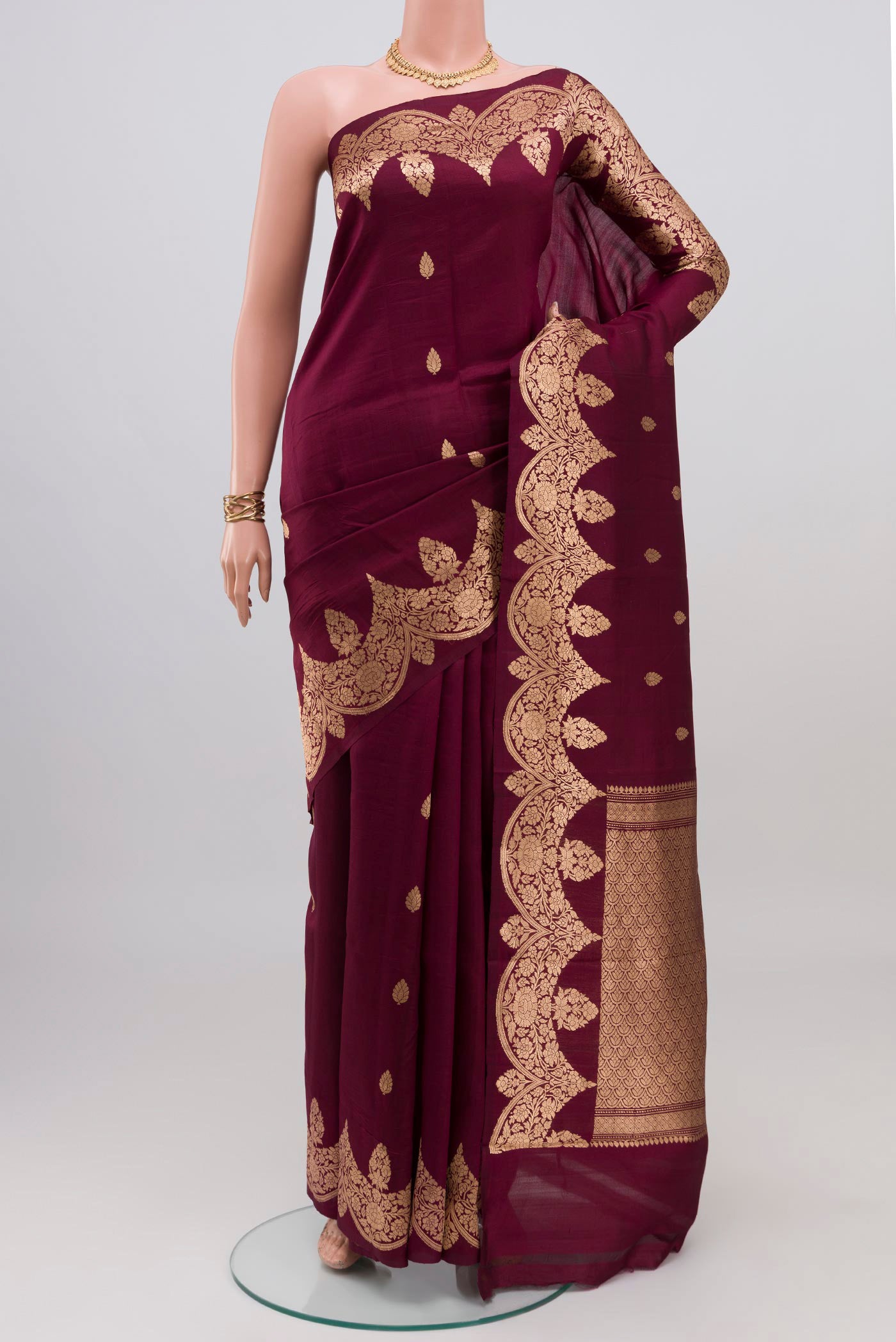 Burgundy Banarasi Katan Silk Saree with Zari Butta on the body and Fancy Border.  displayed on a mannequin