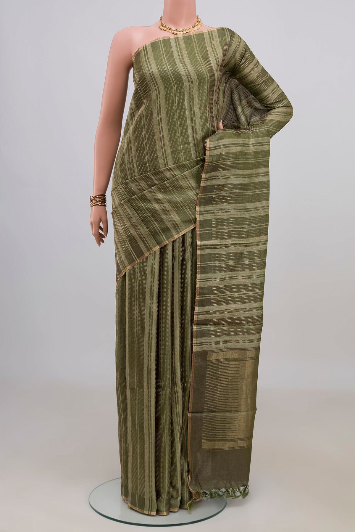 Mehandi Green Tussar Saree with Stripes on the body and Thin Zari Line.  displayed on a mannequin